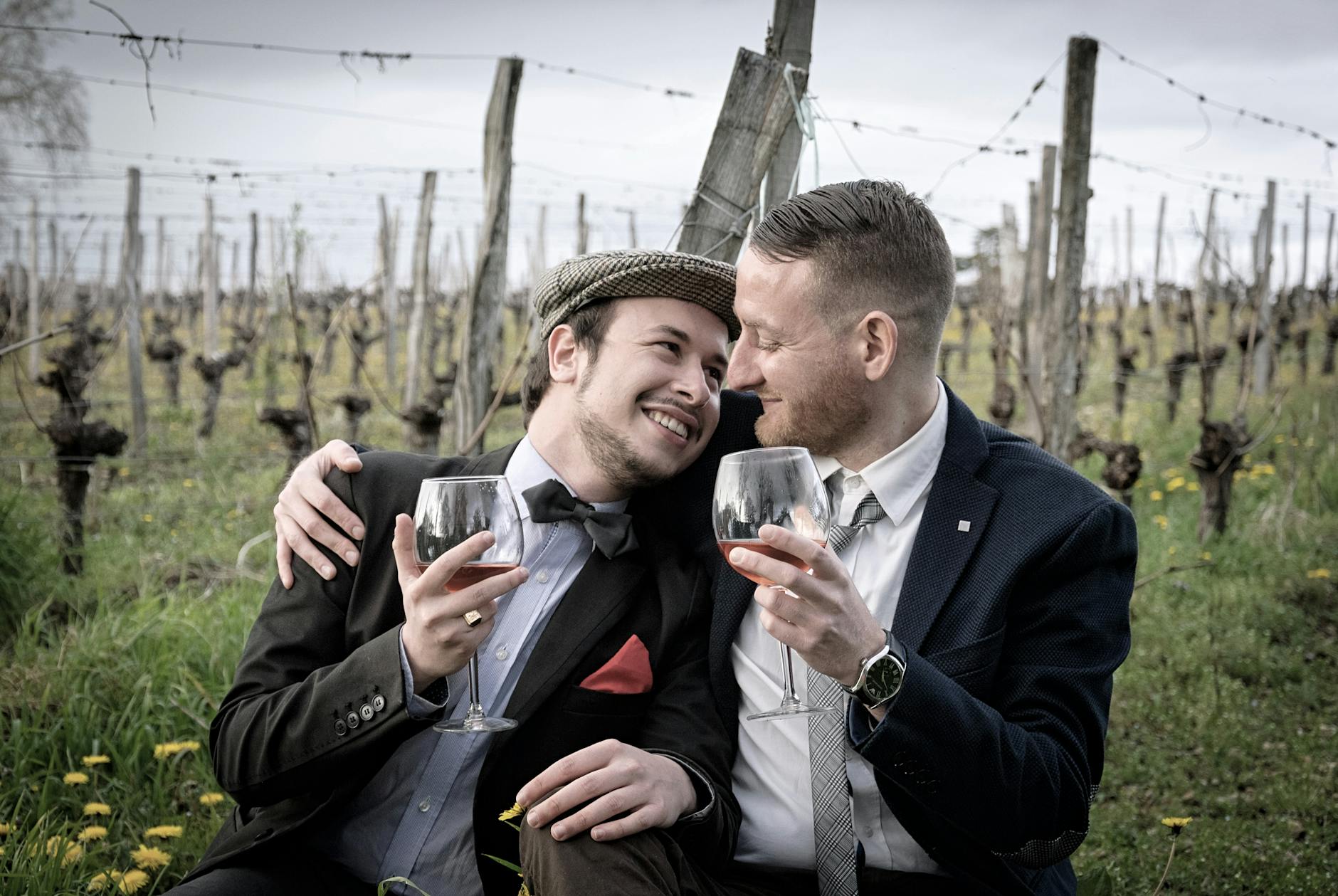 Happy couple in vineyard hugging and sharing a glass of wine, showcasing romance and joy outdoors. - spring dating tips