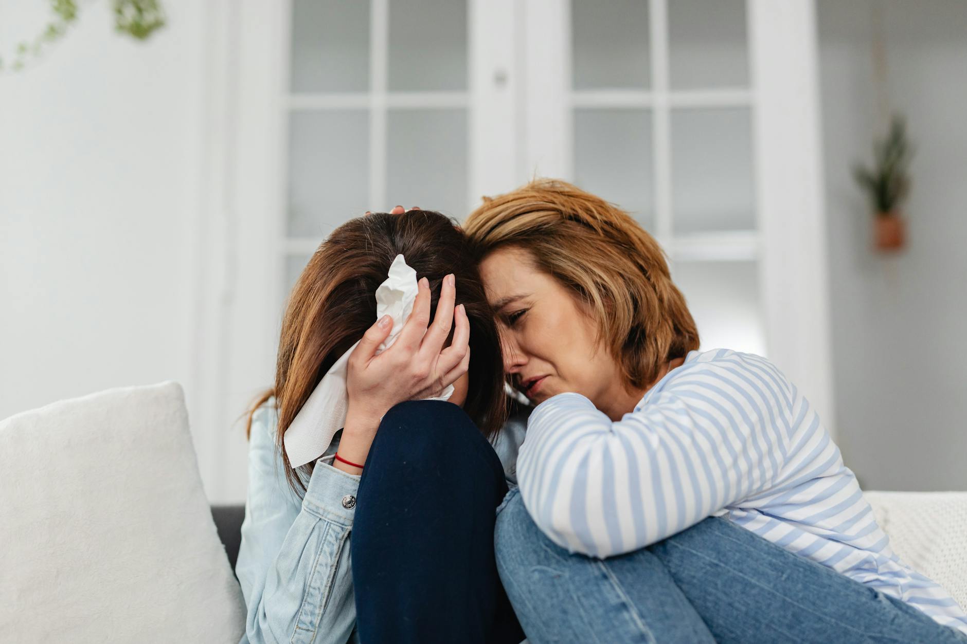 Two women share an emotional moment, conveying comfort and empathy indoors. - spring depression help