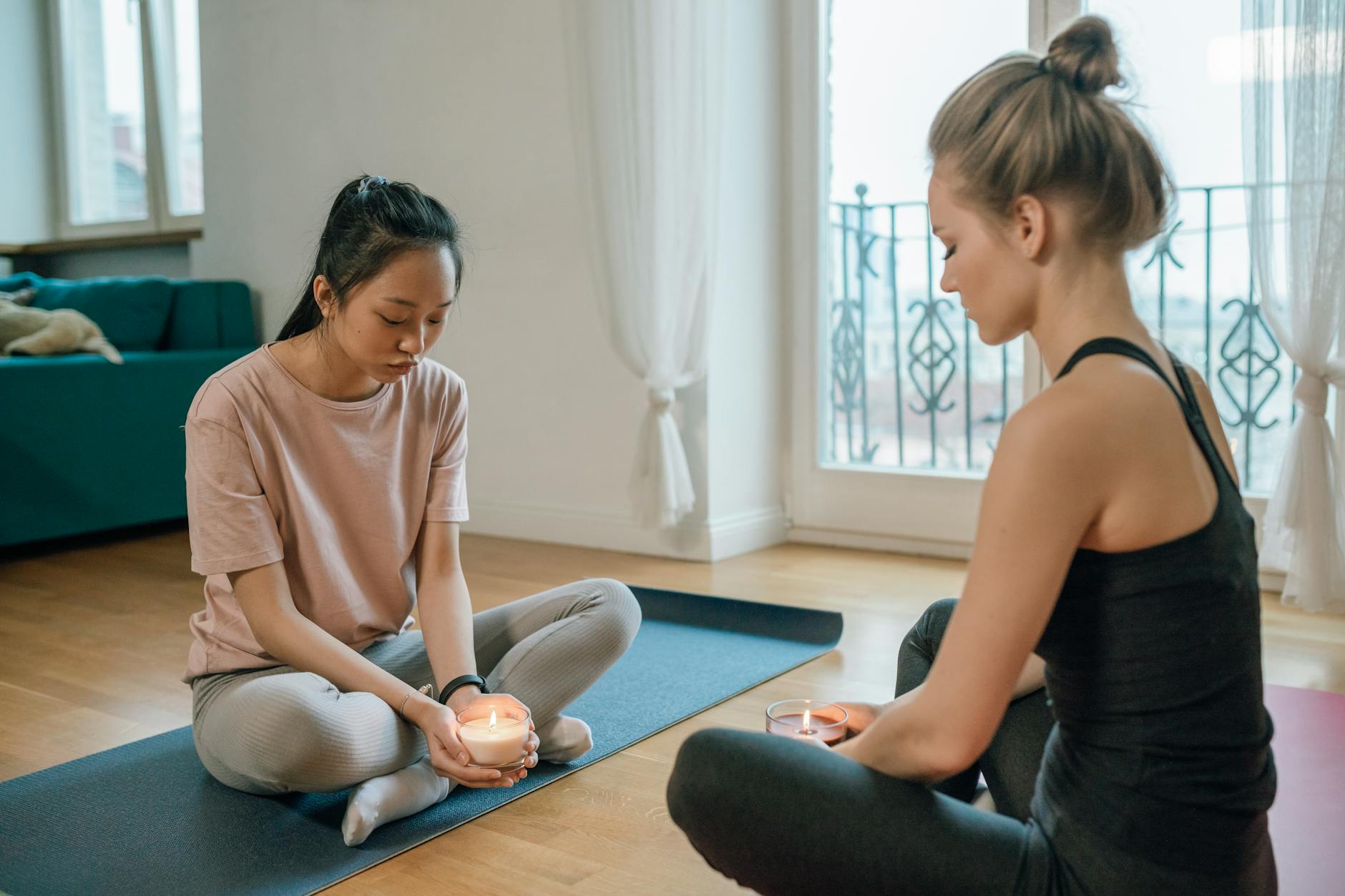 Two women relax and meditate with candles indoors, promoting mental wellness. - spring mental clarity