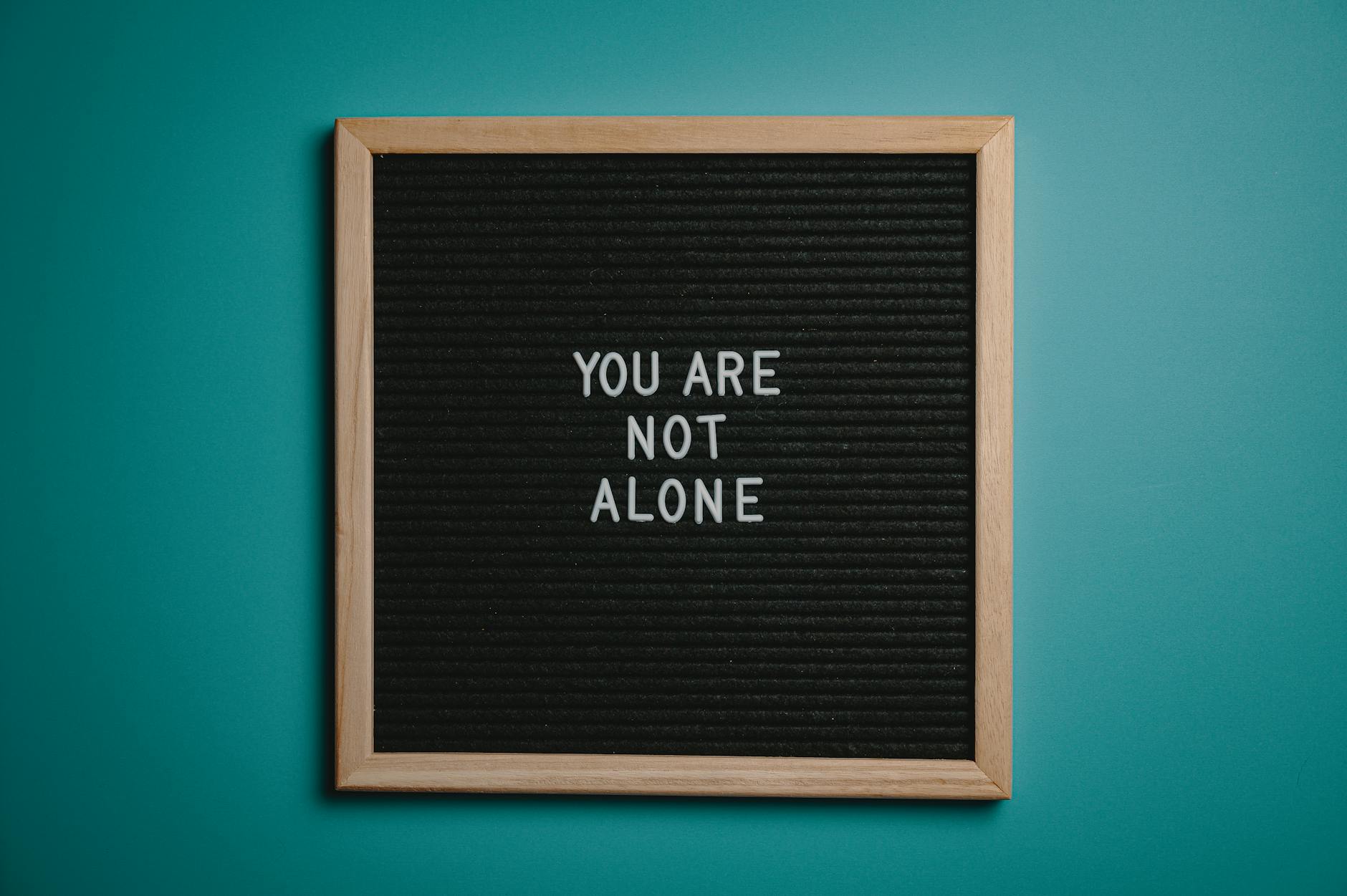 A wooden letter board displays a motivational message against a teal background. - spring mental reset