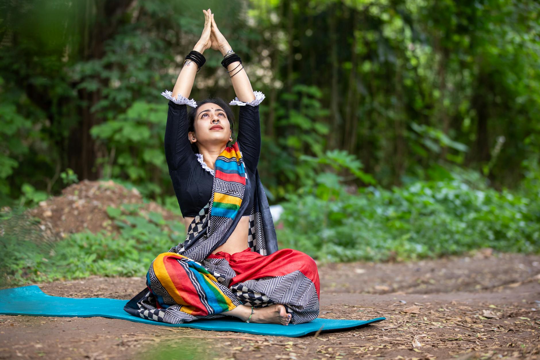 South Asian woman practicing yoga outdoors, embracing wellness and mindfulness in vibrant attire. - spring mindfulness practices