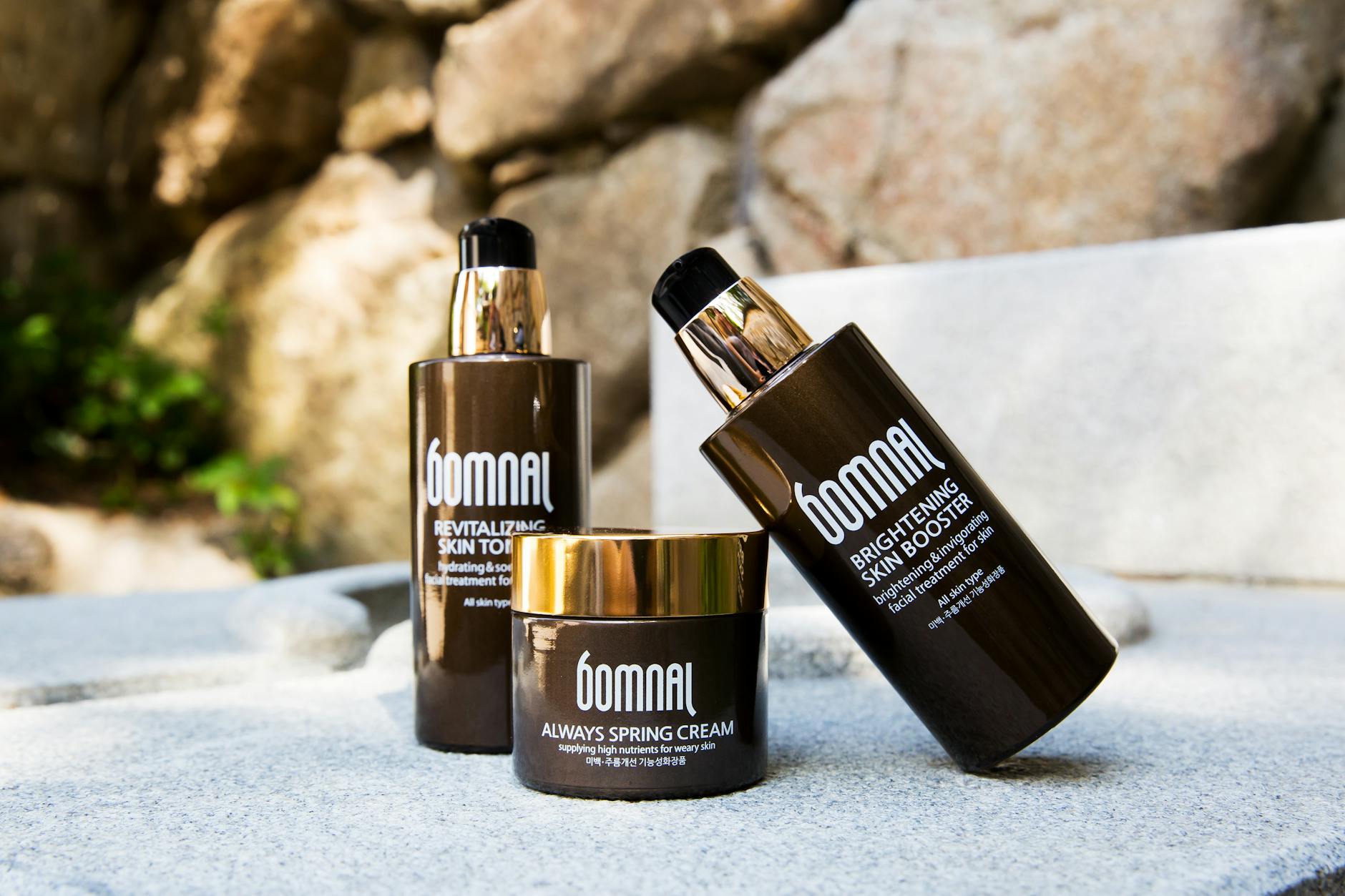 High-end skincare products displayed outdoors, featuring revitalizing toner and brightening booster. - spring self-care