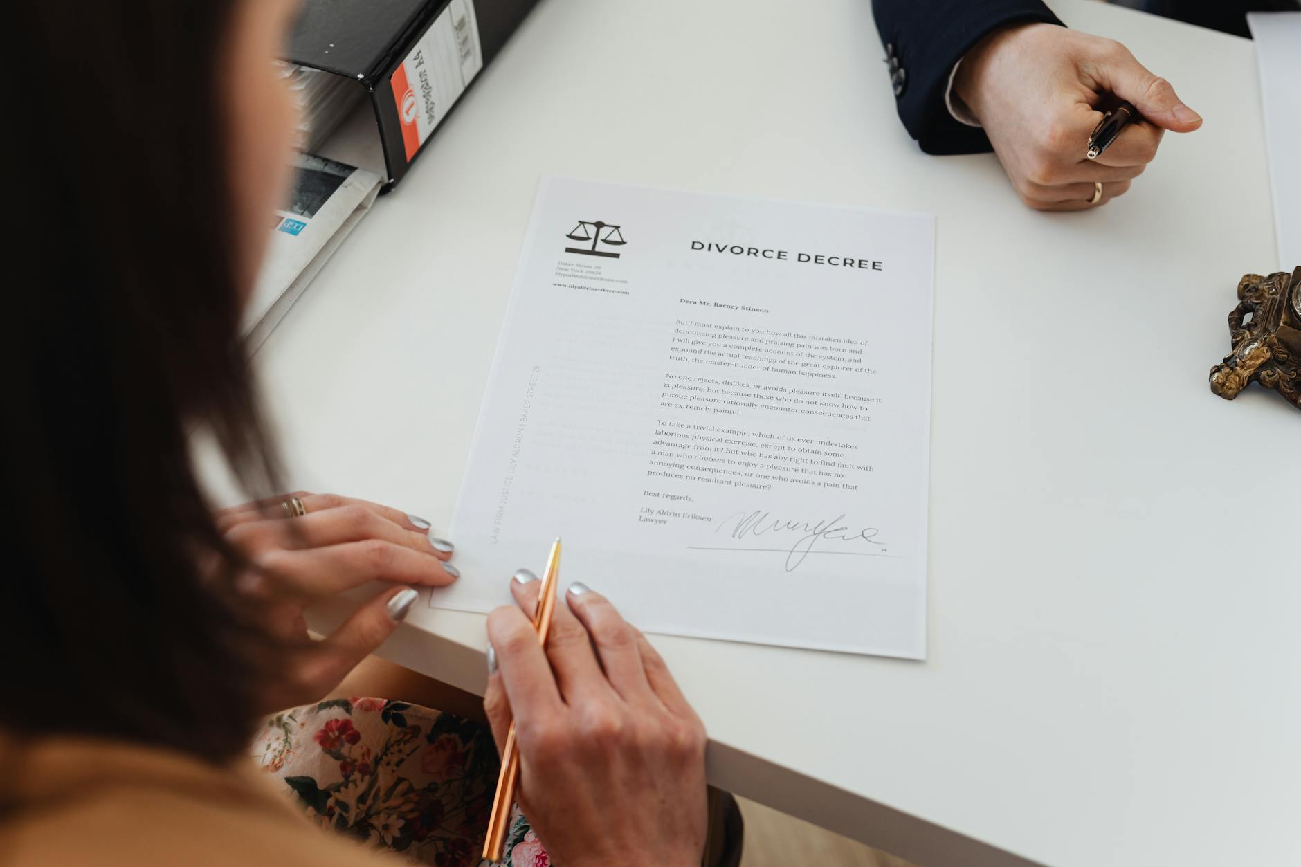 A close-up shot of two people signing a divorce decree at a law office table. - start dating after divorce