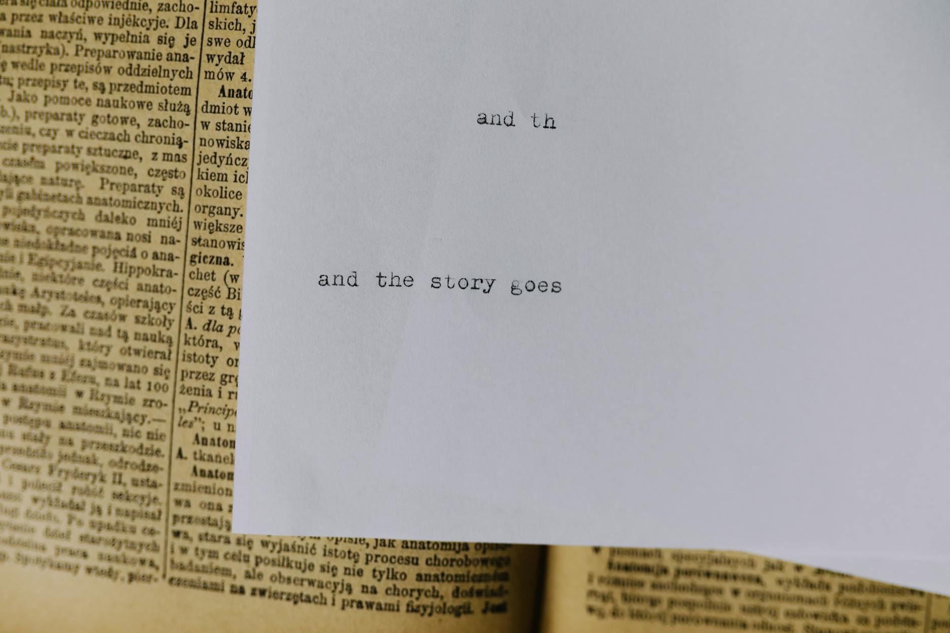 A piece of paper with typewritten text 'and the story goes' over an old book page. - story resolution meaning