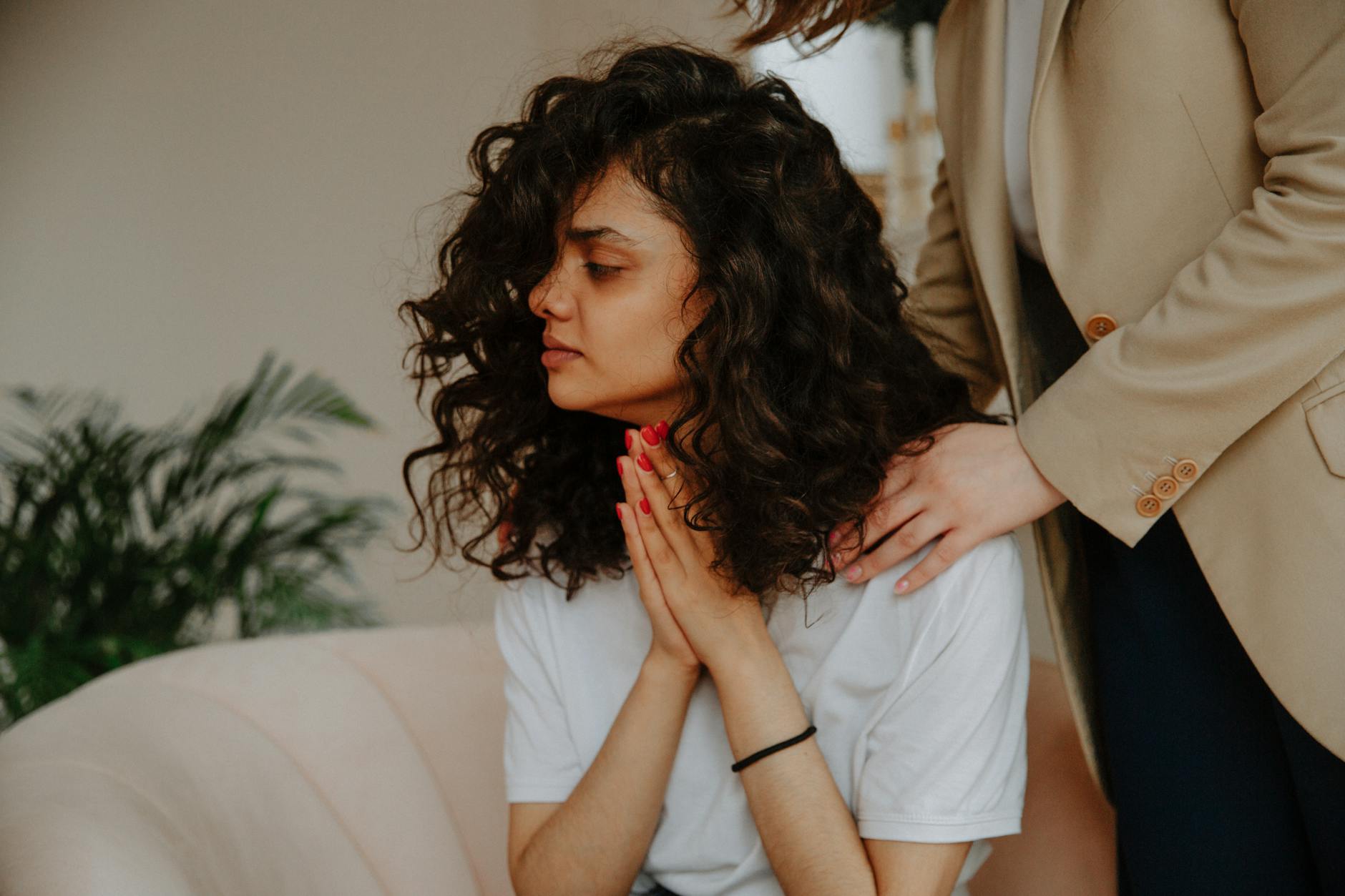 A young woman receives emotional support during a therapy session indoors. - therapist for depression