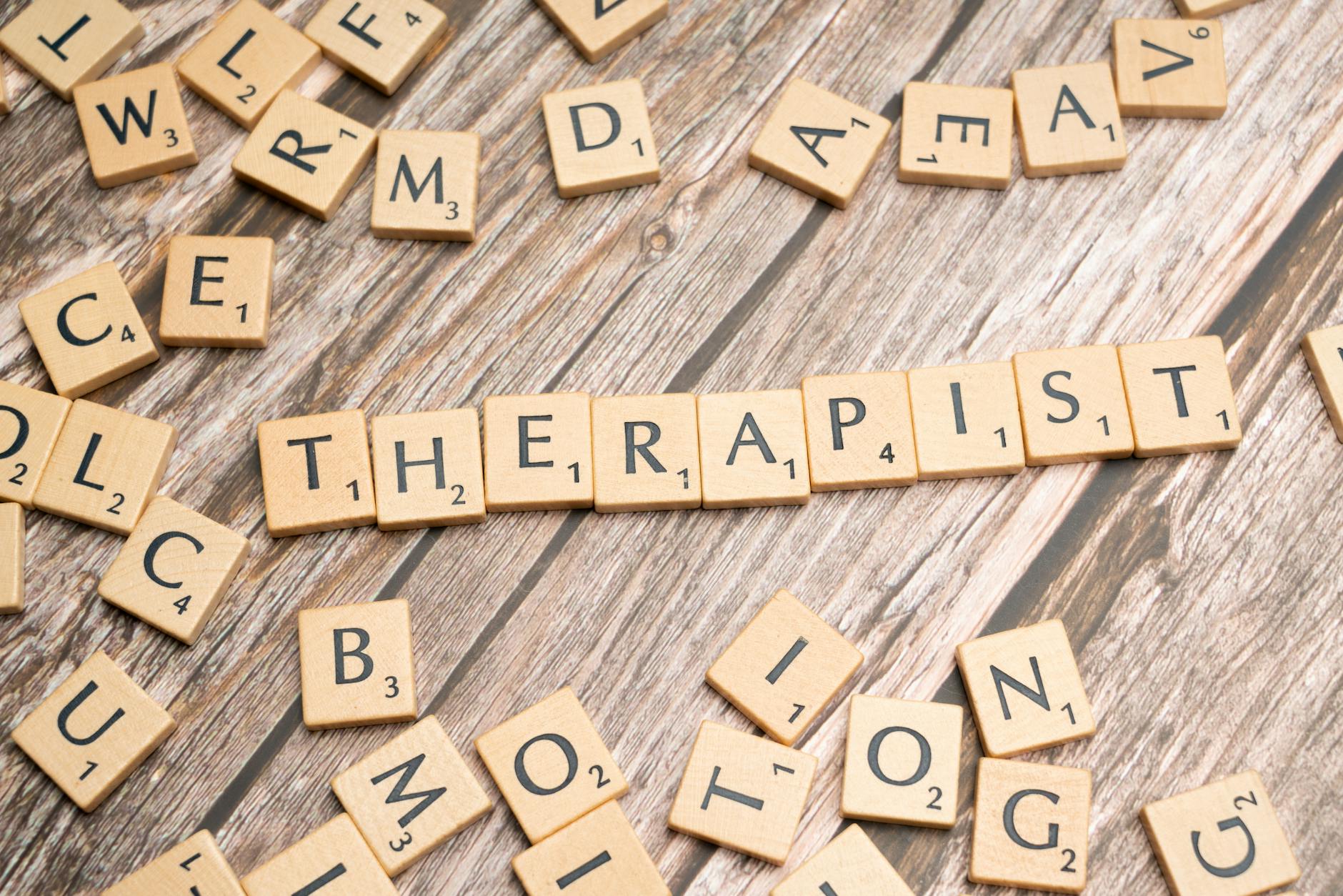 Wooden letter tiles on a rustic surface spell the word 'Therapist'. - therapist for seasonal mood shifts