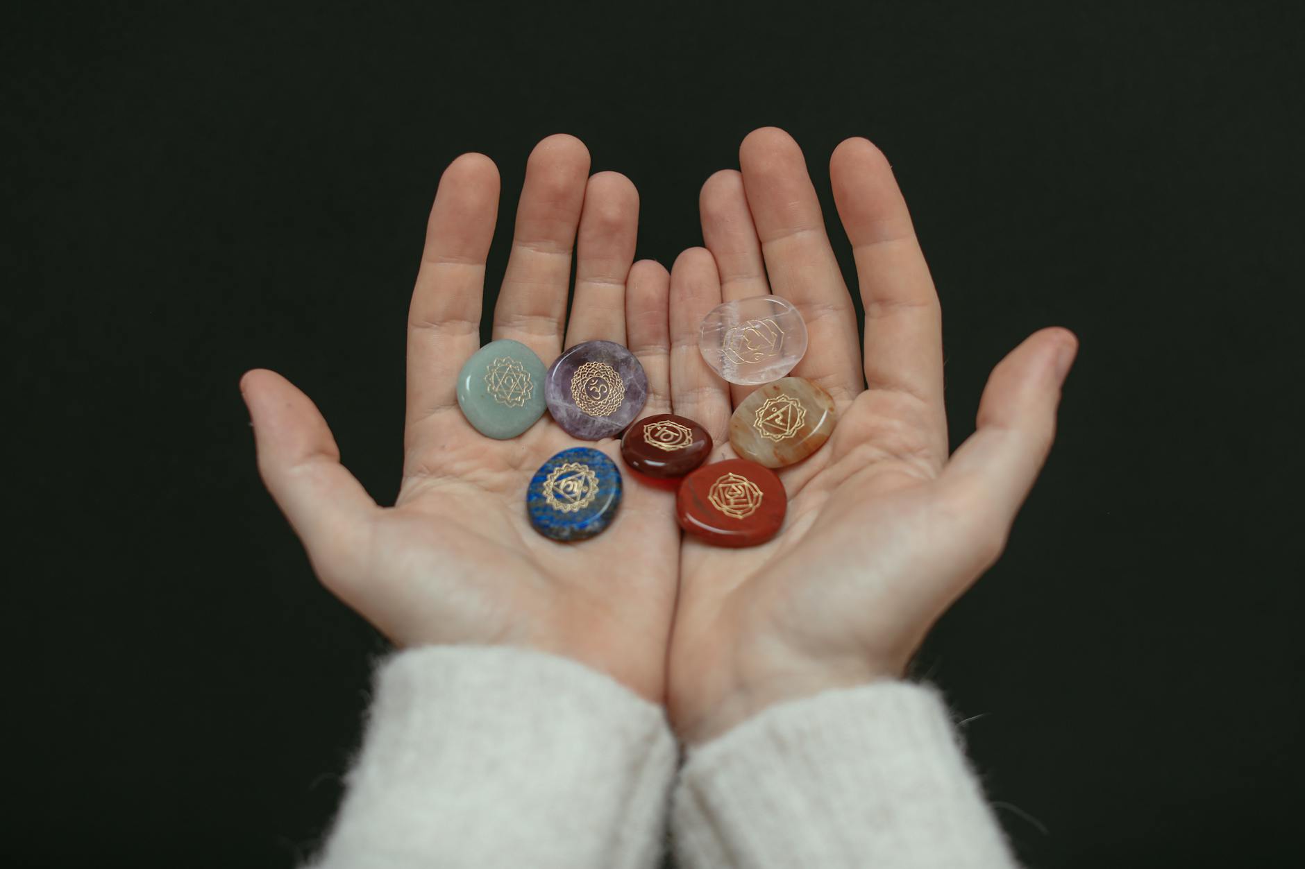 A close-up image of chakra stones held in open hands, showcasing spiritual balance. - therapy intentions
