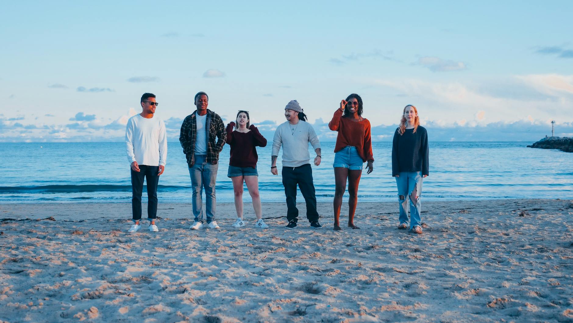 Diverse group of adults socializing on a sandy beach during sunset. - toddler spring break