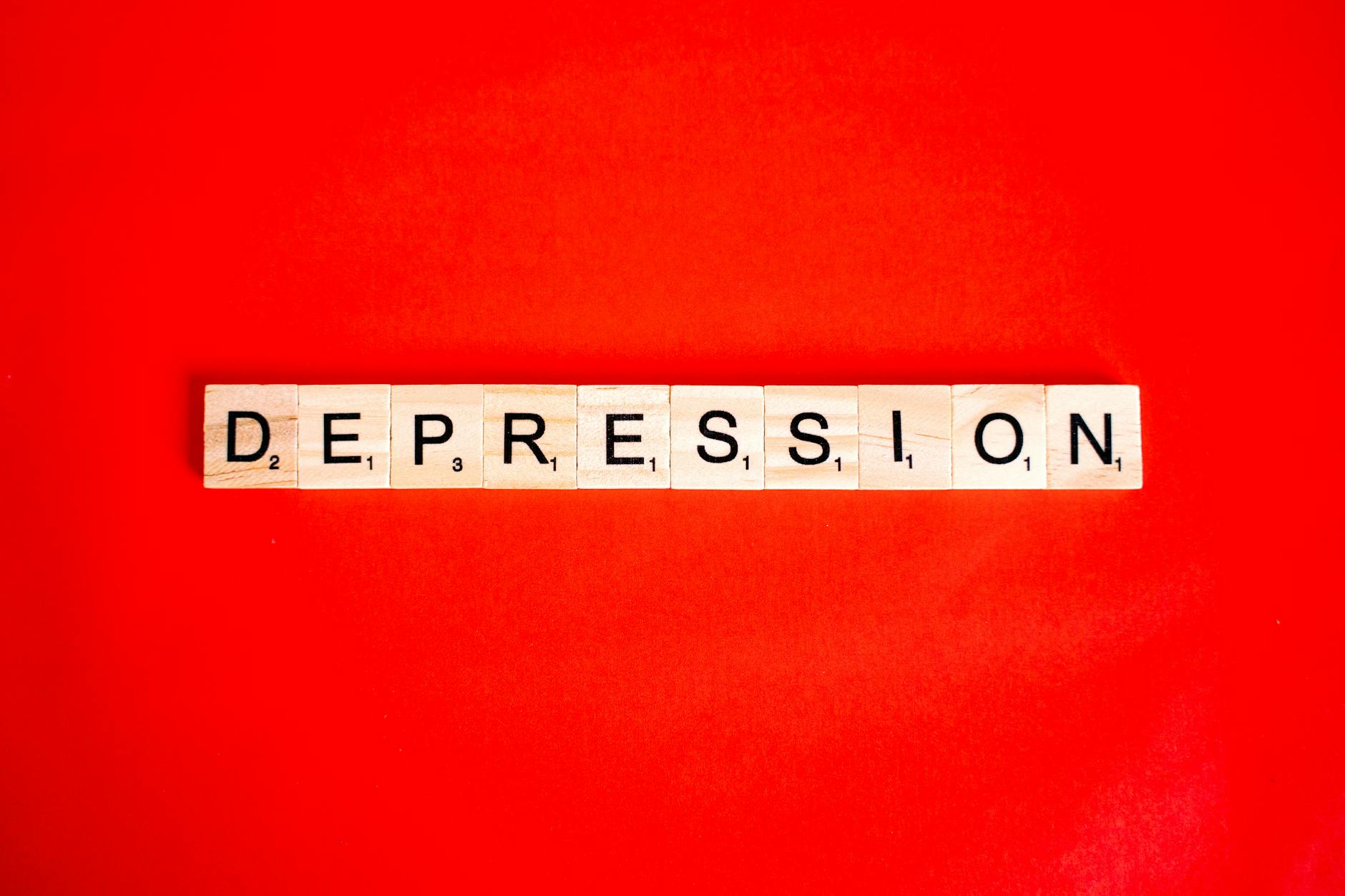 Word depression spelled with letter tiles on vibrant red background, highlighting mental health theme. - types of anxiety disorders