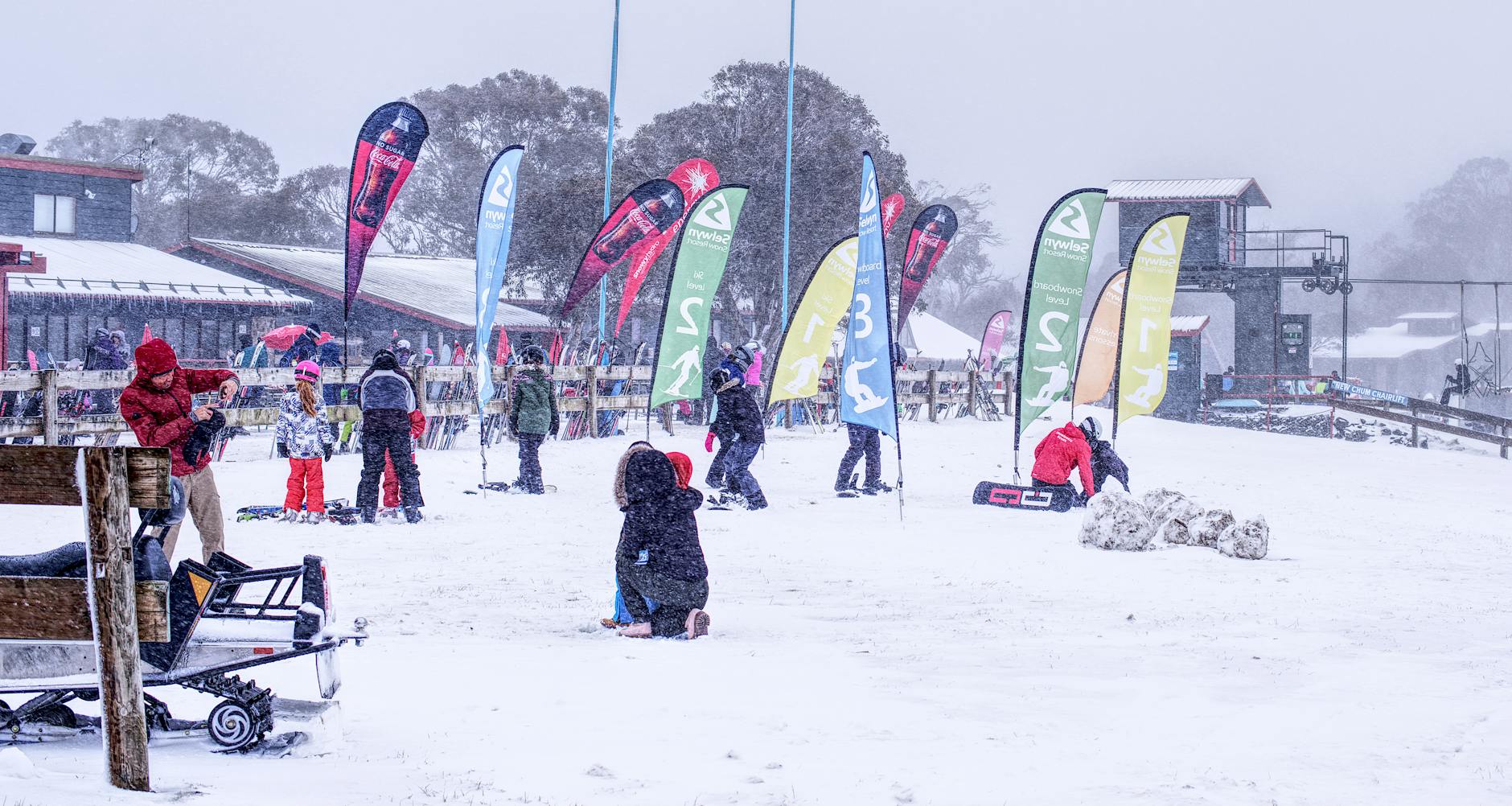 A snowy day at a ski resort with families enjoying winter activities outdoors. - winter anxiety children