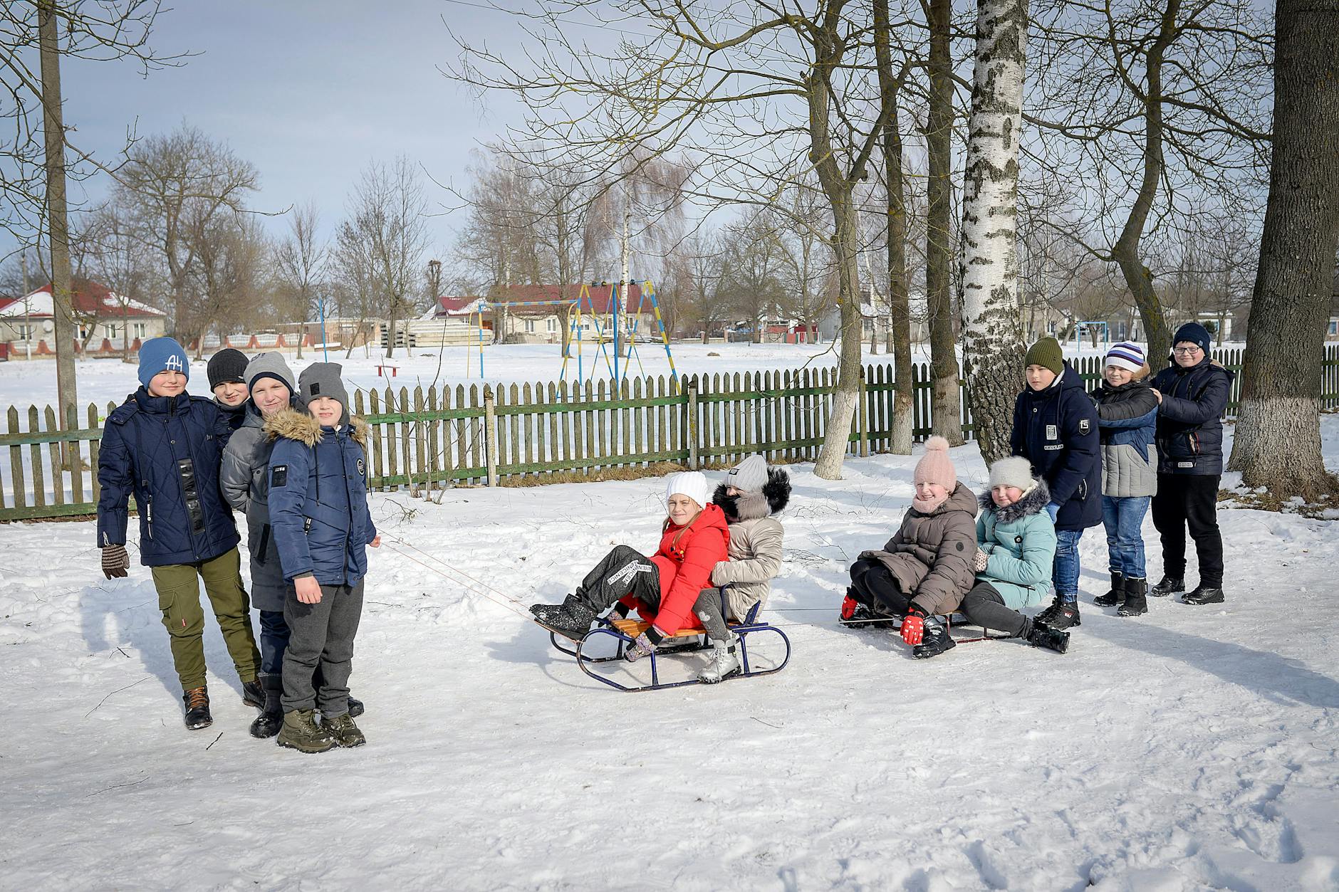 Group of children sledding in a snowy park, enjoying winter activities. - winter kids activities