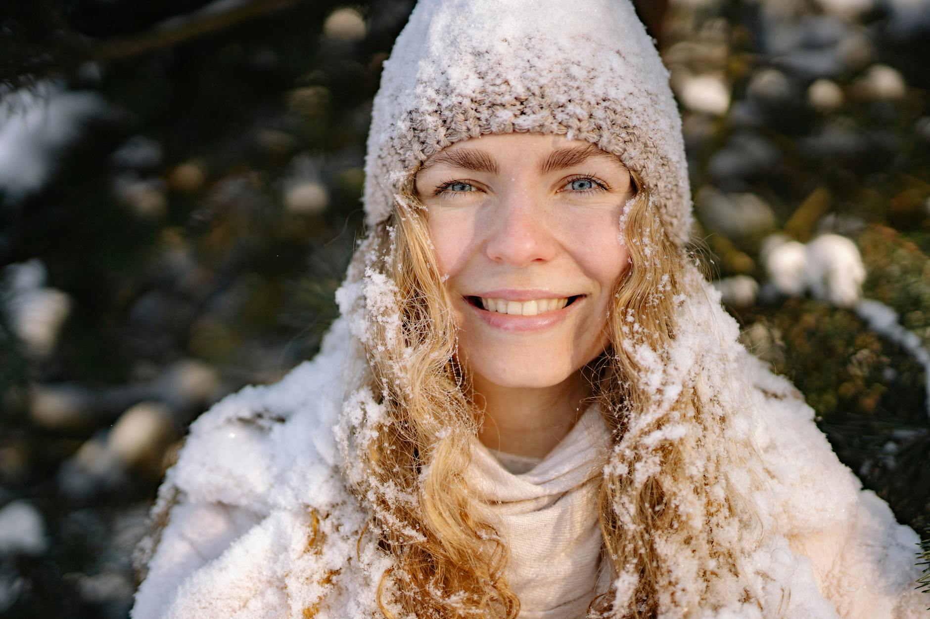 Happy woman with curly hair enjoying winter snow outdoors, wearing a cozy knitted cap. - winter sadness therapy