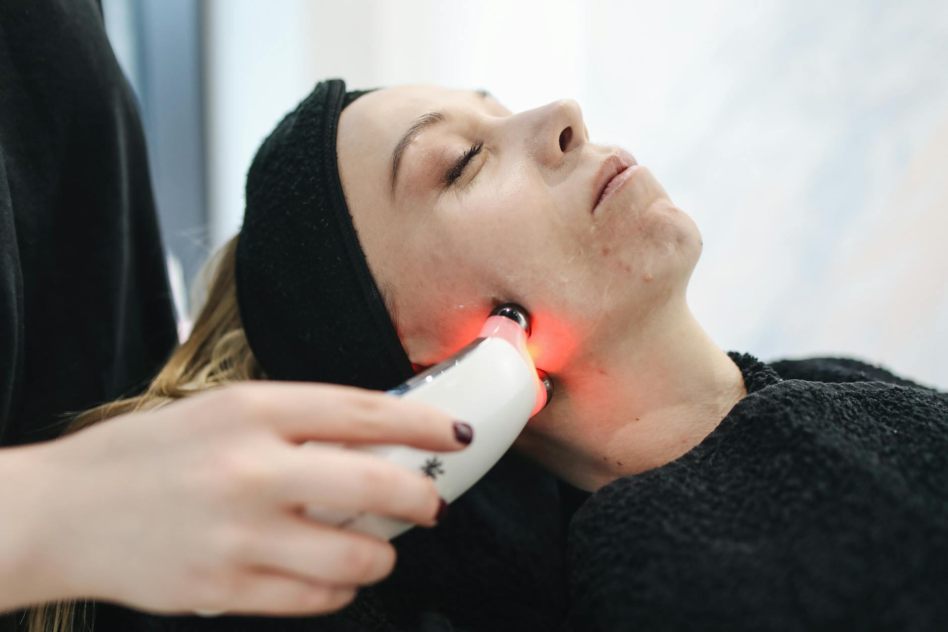 An adult woman receives a laser facial treatment in a modern skincare clinic. - winter sluggishness treatment