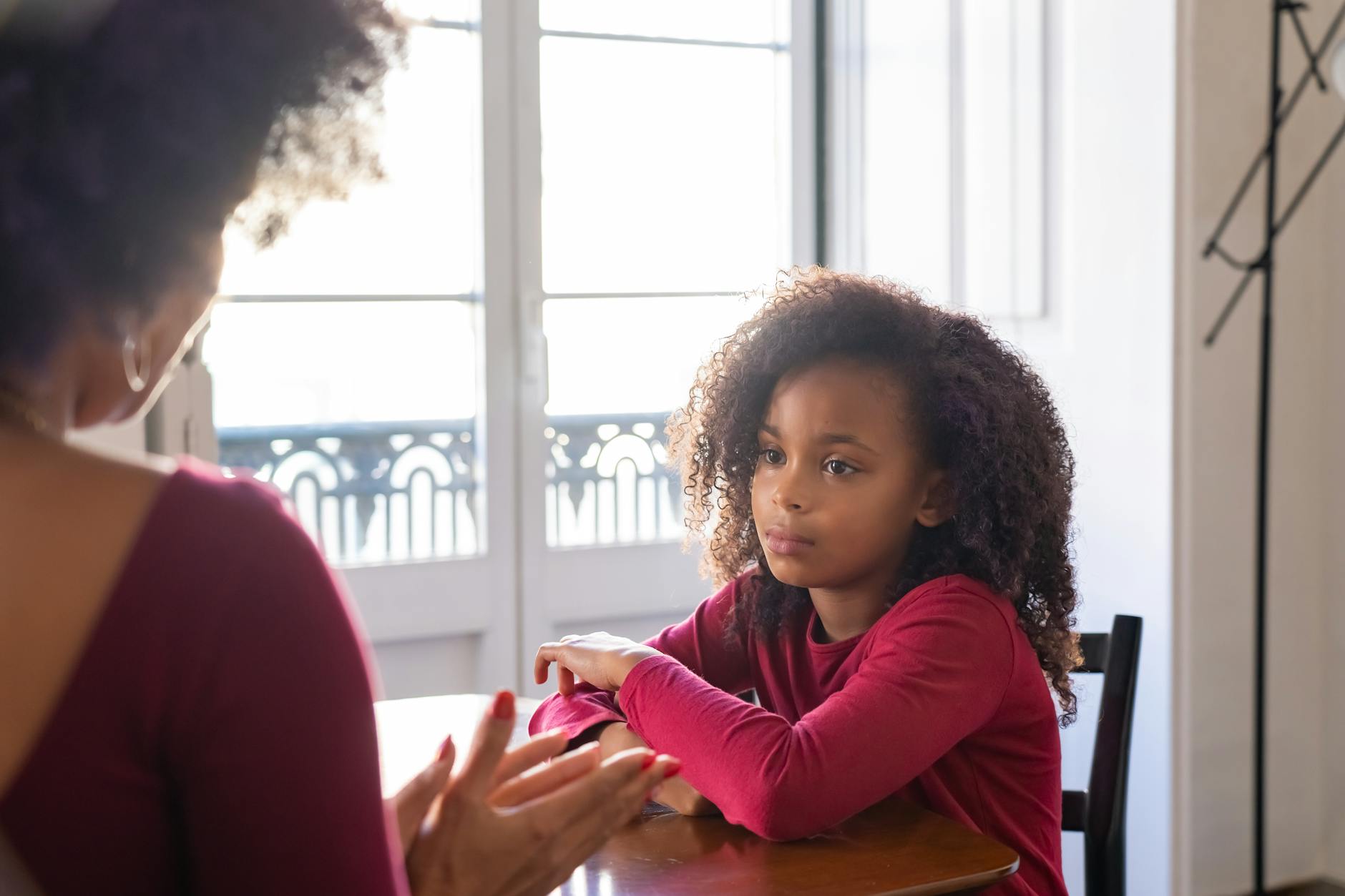 A mother talks to her daughter in a warm family setting, highlighting parenting dynamics. - active listening parents
