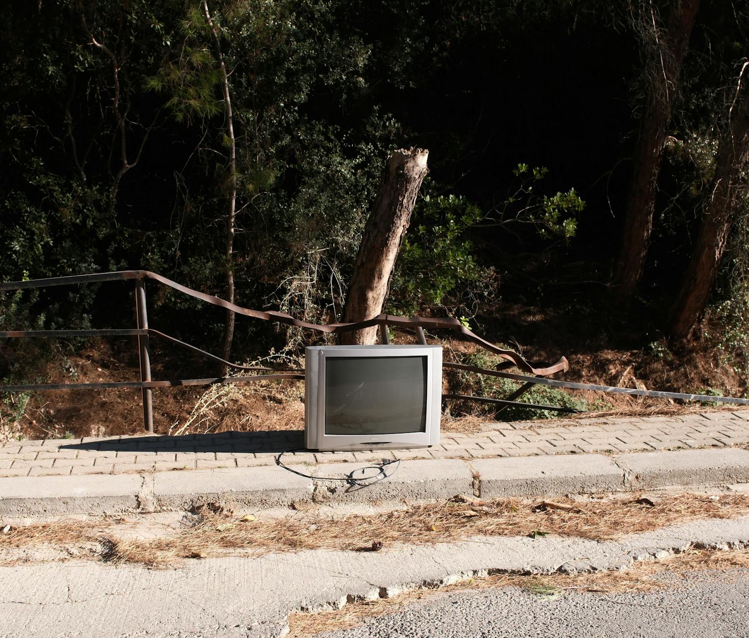 An abandoned tube television on a sidewalk surrounded by nature in Izmir, Türkiye. - anger management tv shows