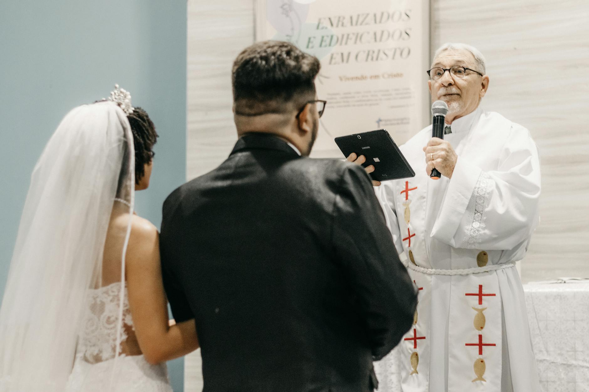 A priest officiates a wedding ceremony, speaking to the newlywed couple in a church setting. - biblical marriage advice