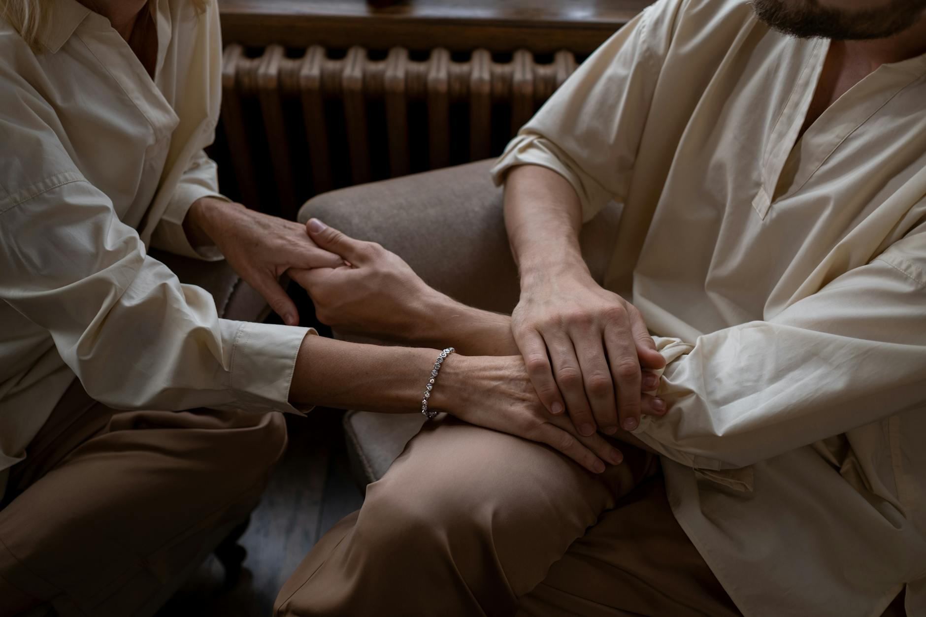 Close-up of a couple's hands entwined, capturing affection and connection in an indoor setting. - build trust partner