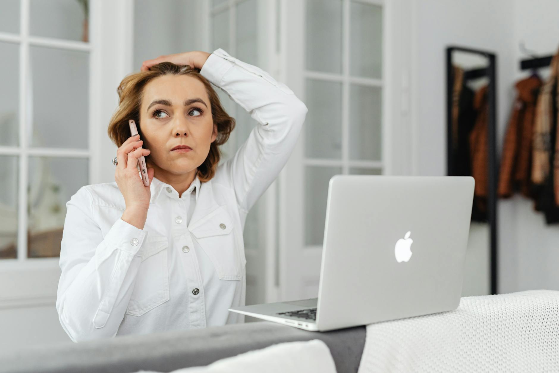 Caucasian woman multitasking with smartphone and laptop in modern home office. - communicate needs busy season
