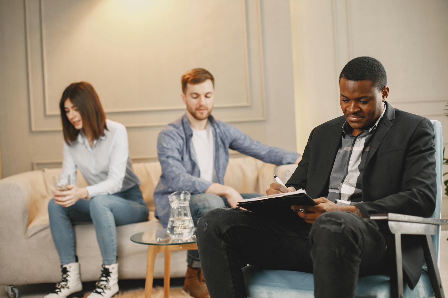 A couple discussing issues with a therapist during a counseling session indoors. - couples therapy benefits