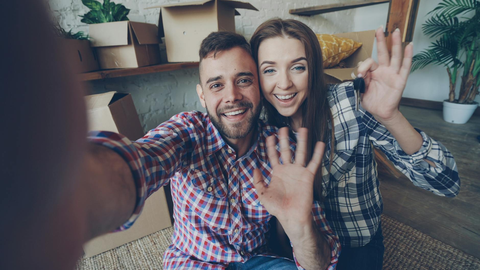 Cheerful couple celebrating moving into their new home, surrounded by boxes. - couples therapy fresh start