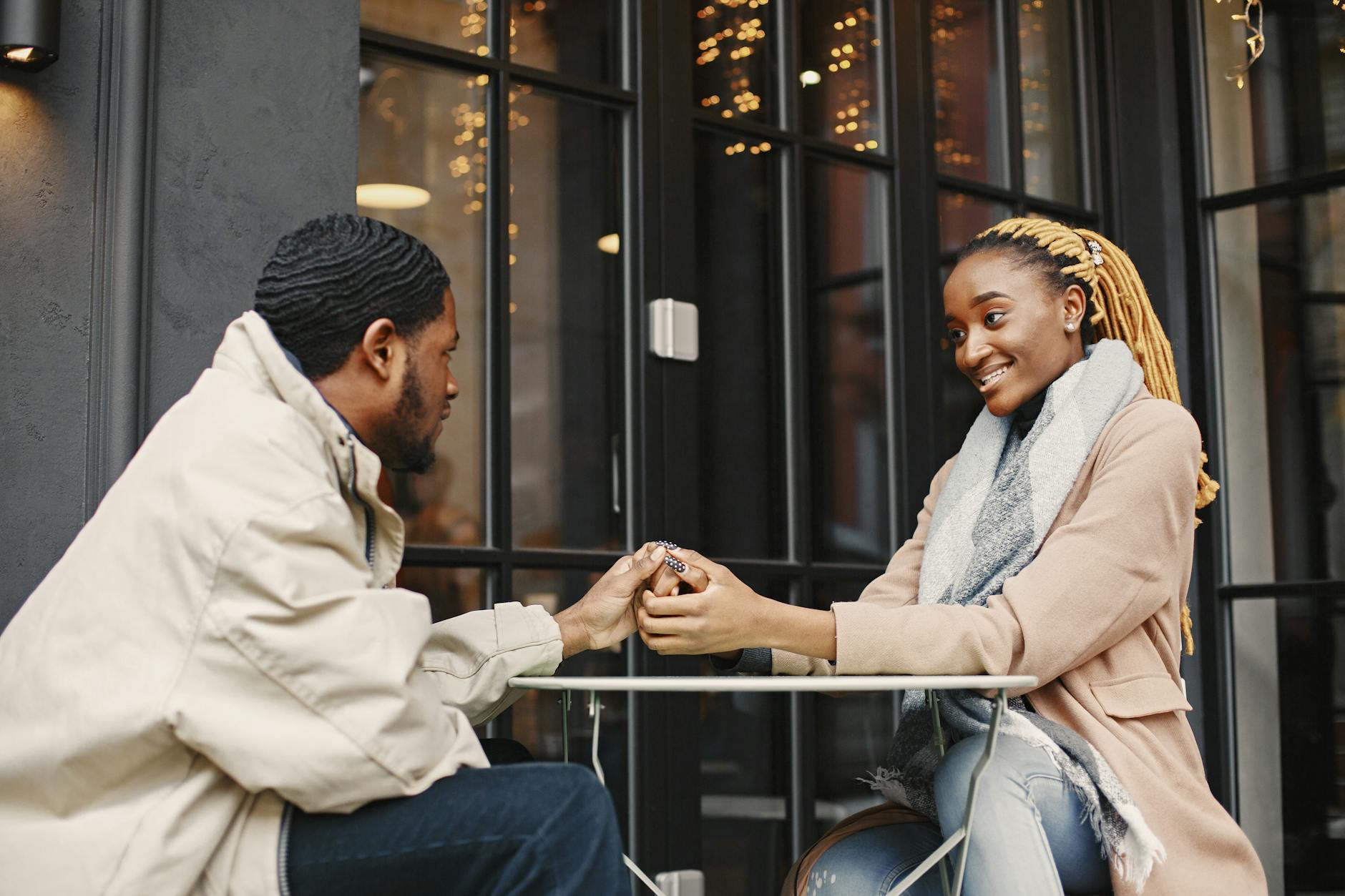 A couple enjoying a warm and cozy winter date at a cafe, expressing affection and joy. - dating in 30s