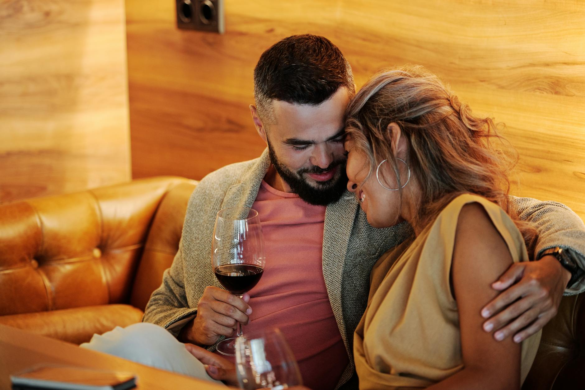 Loving couple embracing with wine glasses. Perfect cozy moment indoors. - dating over 40