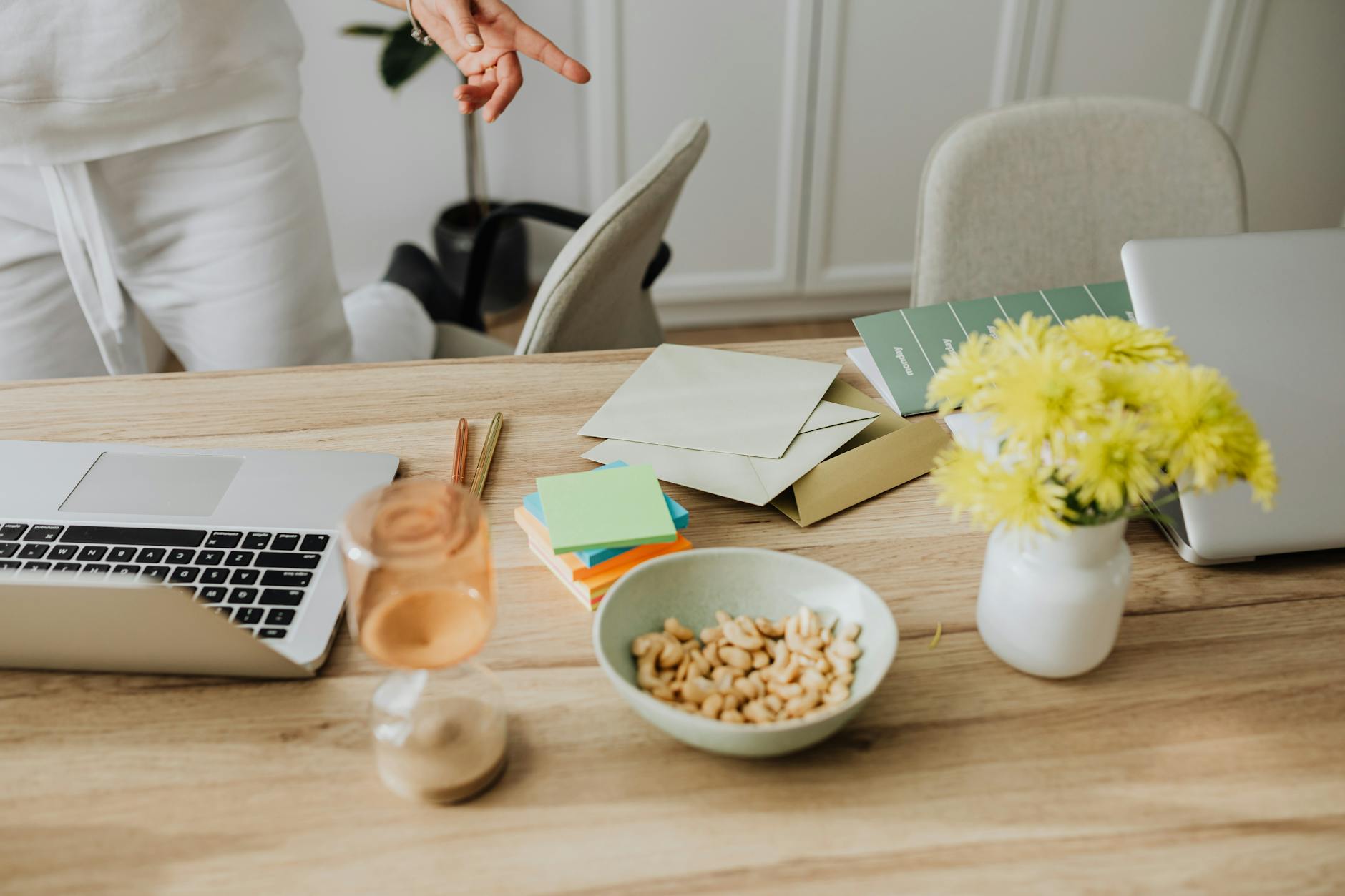 Warm and inviting home office setup with snacks and vibrant flowers on a wooden desk. - declutter communication