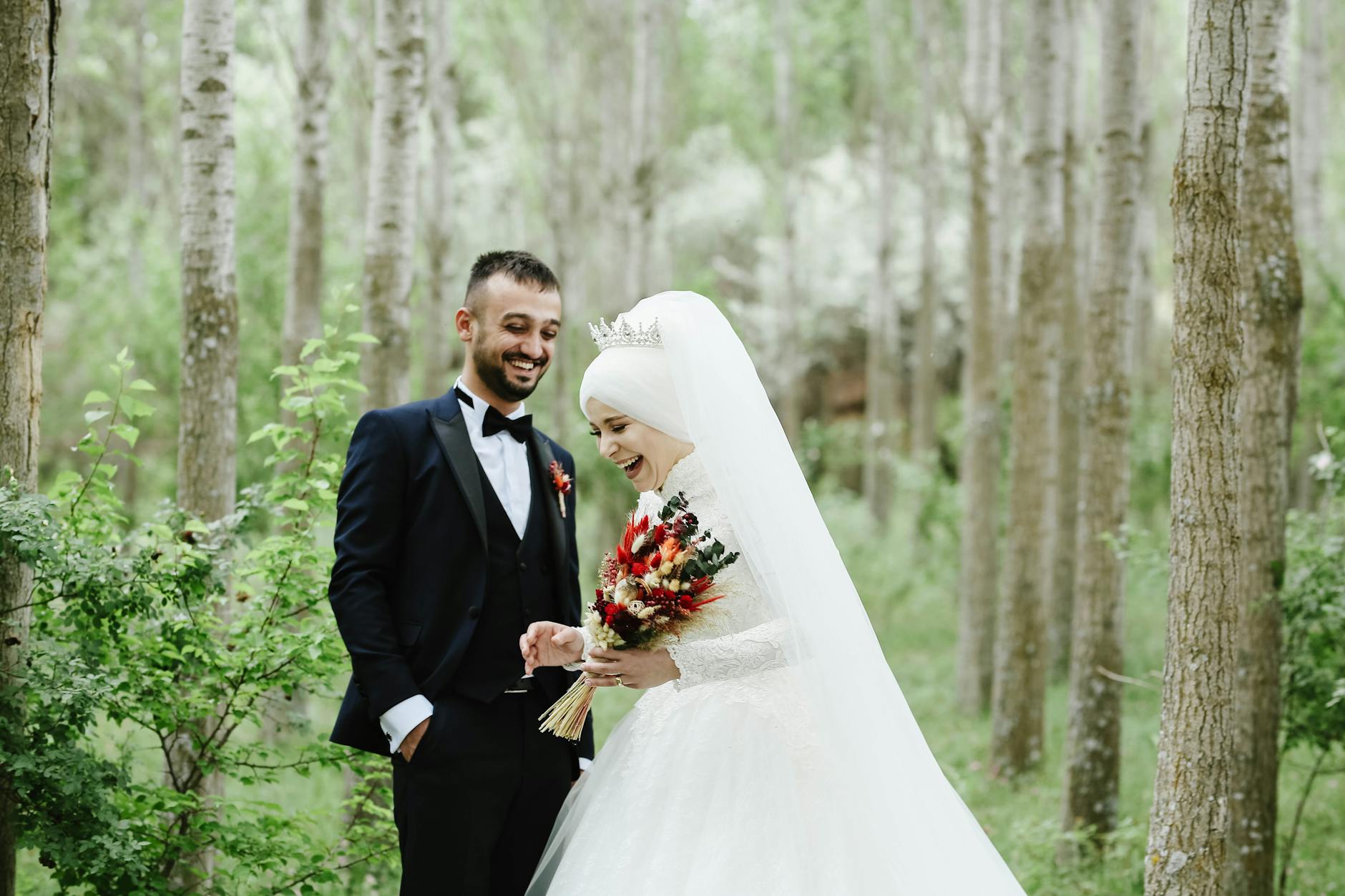 A happy bride and groom sharing a joyful moment in a beautiful green forest. - expressing needs marriage