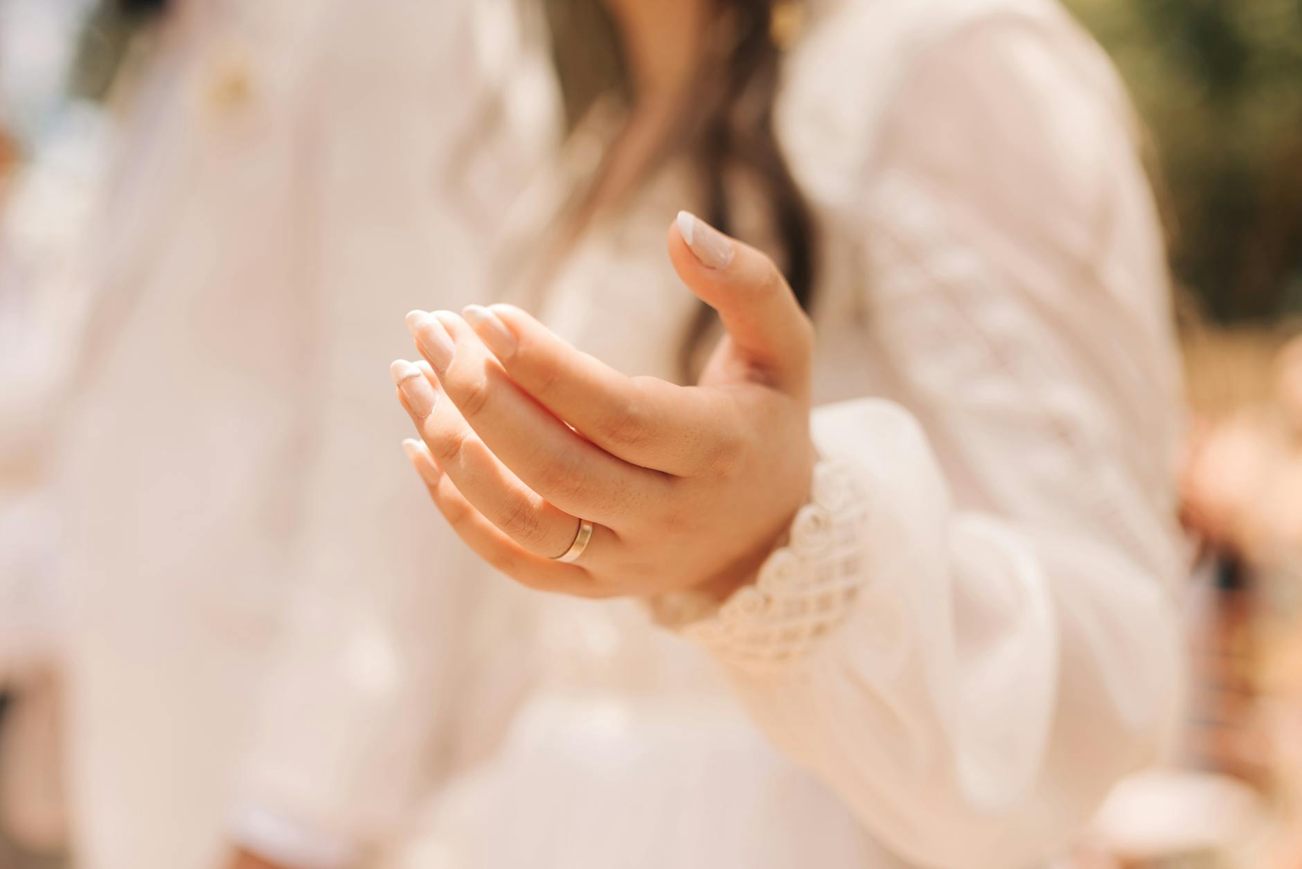 Close-up of a woman's hand in a gentle gesture, outdoors in bright light. - expressing needs marriage
