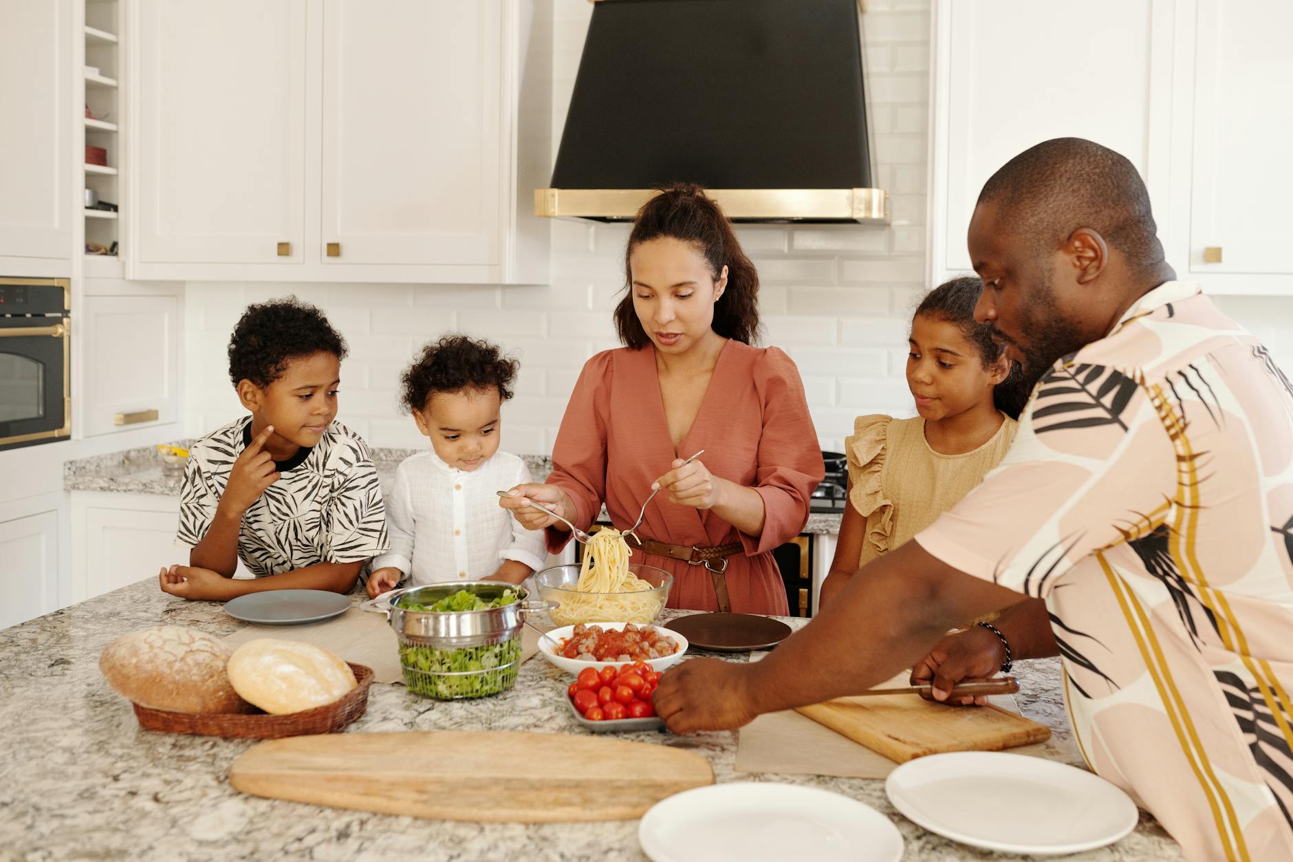A diverse family prepares pasta in a modern white kitchen, conveying unity and culinary art. - family communication skills