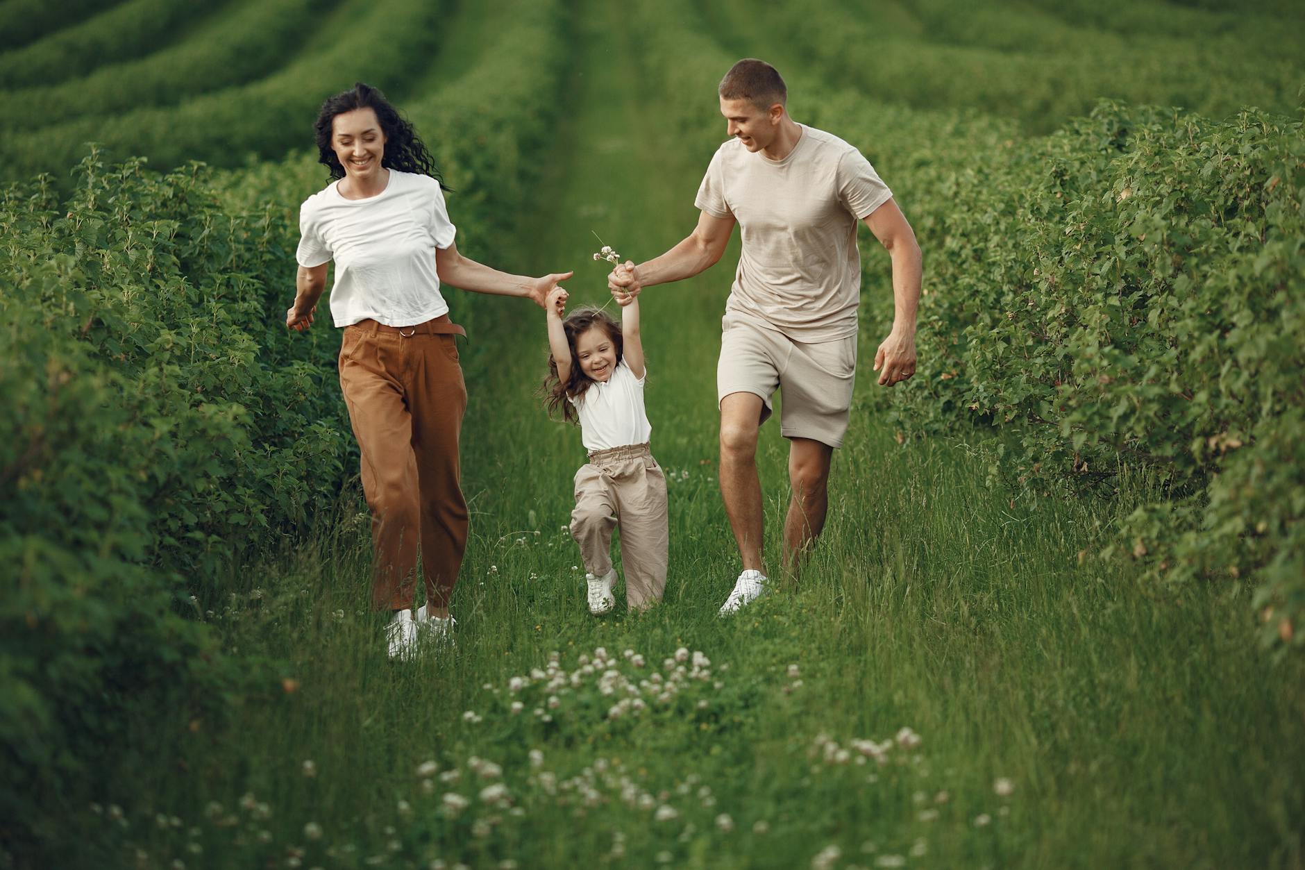 Joyful family enjoying a fun day outdoors in a green field, epitomizing togetherness and happiness. - family therapy spring