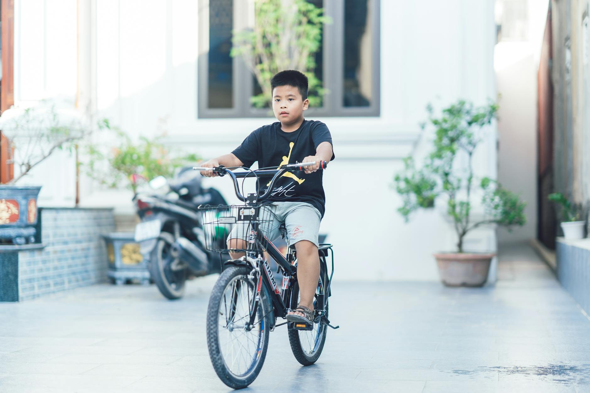 A child riding a bicycle in a courtyard, showcasing outdoor activity and childhood freedom. - fostering child independence