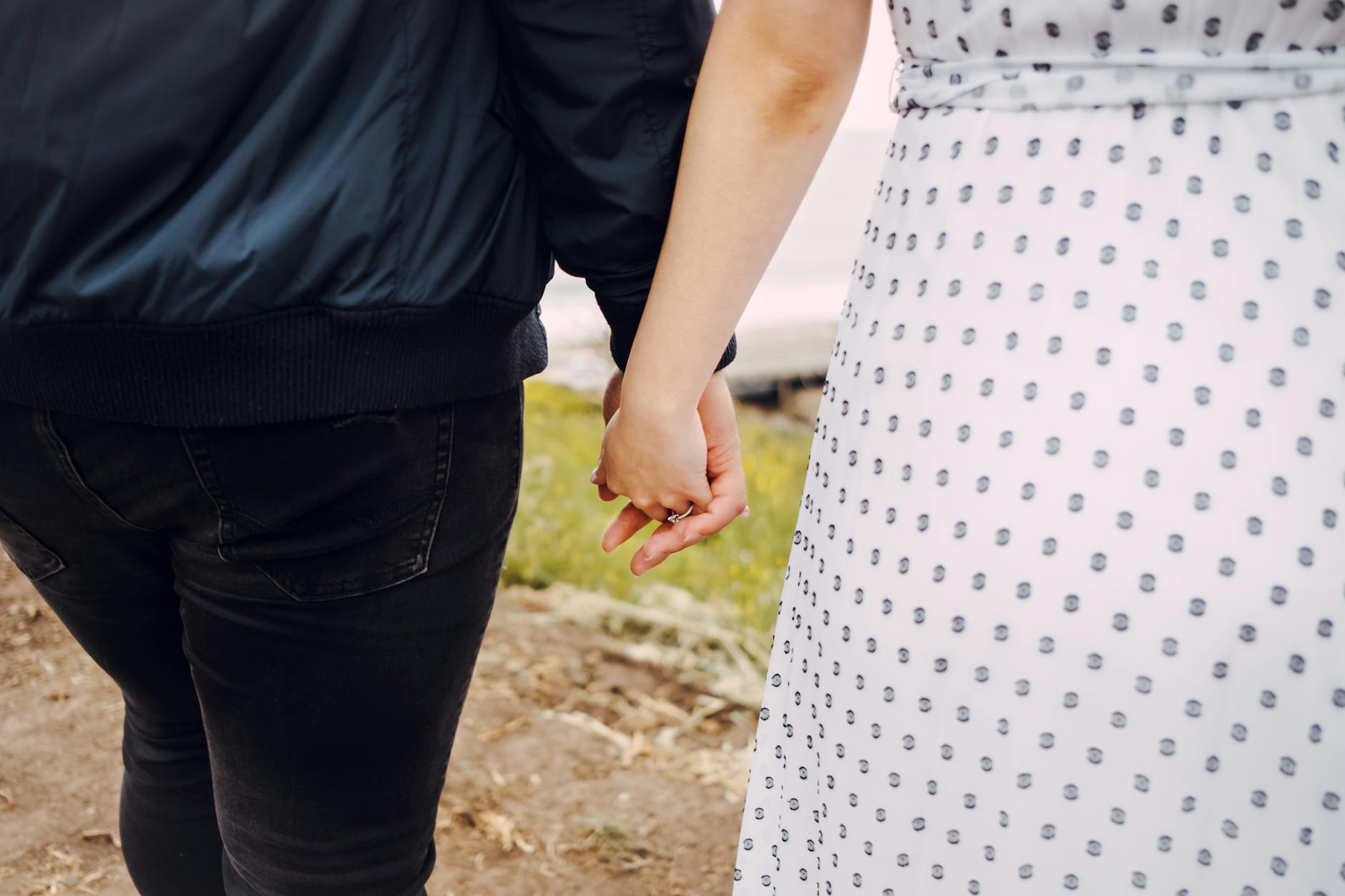 Close-up of a couple holding hands, showcasing love and connection in an outdoor setting. - marriage goals spring