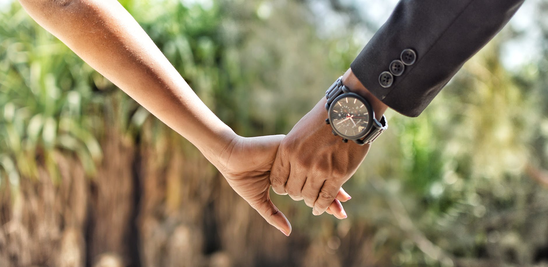 Romantic close-up of a couple holding hands in an outdoor setting, conveying love and connection. - marriage tune up