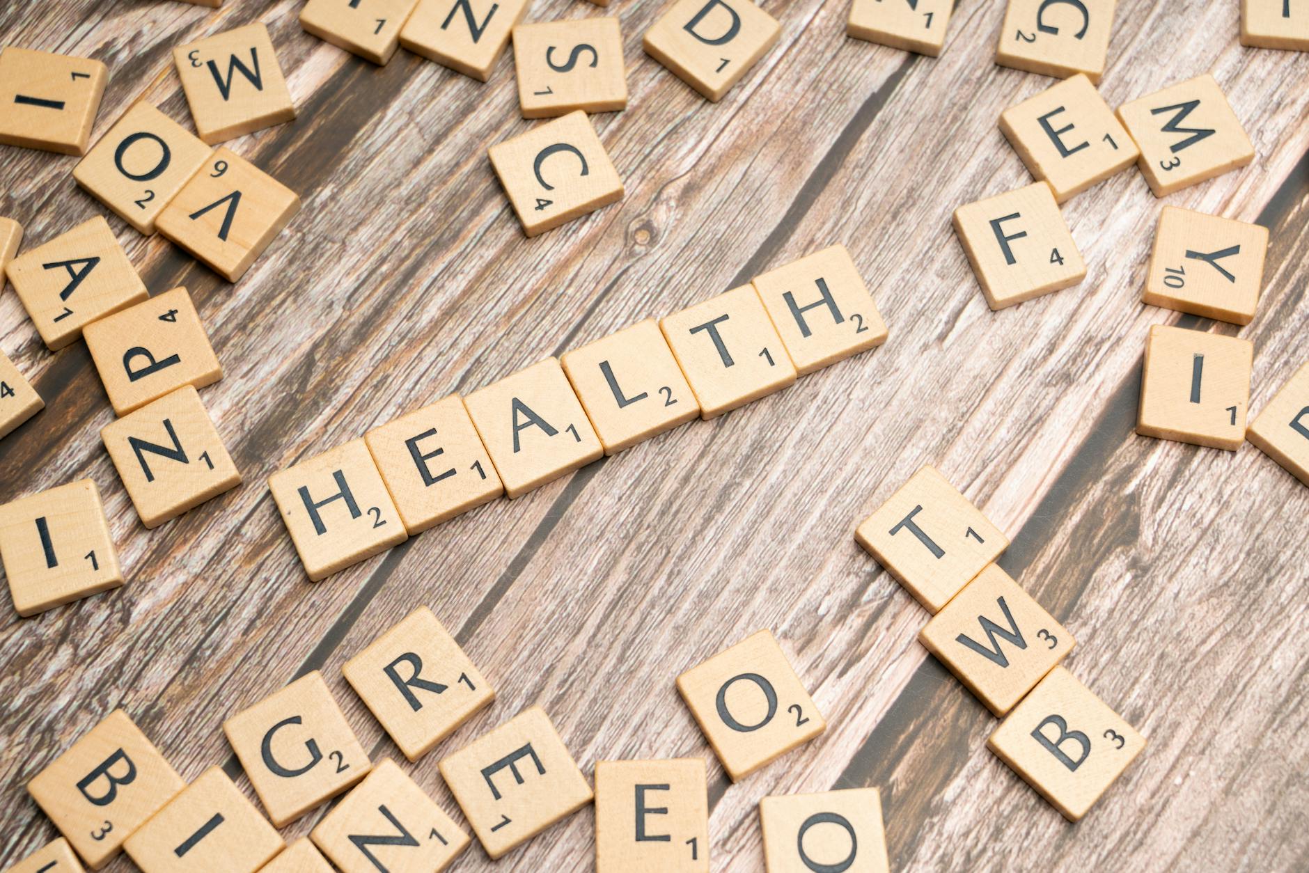 Scrabble tiles spelling 'HEALTH' on wooden surface, symbolizing wellness. - mental health decluttering