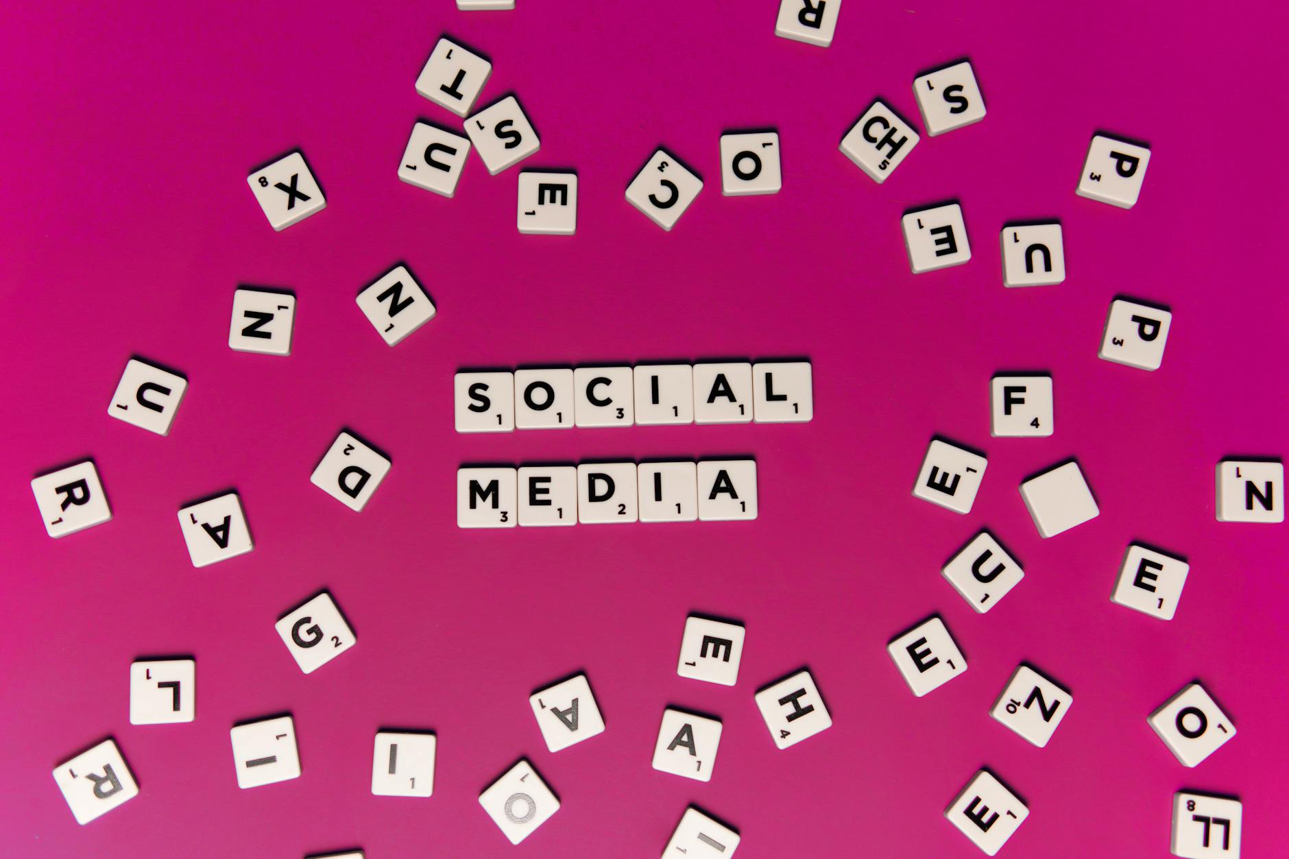 Alphabet tiles forming 'Social Media' on a vibrant pink background, perfect for digital marketing themes. - post-break communication