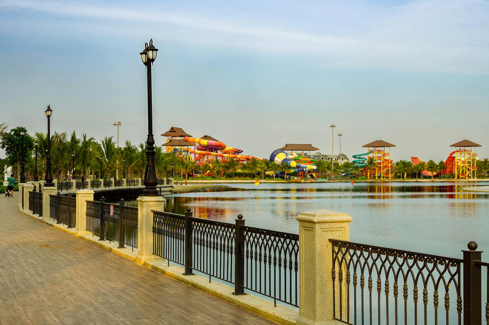 Charming promenade with a view of a vibrant water park across a serene lake. - post vacation blues