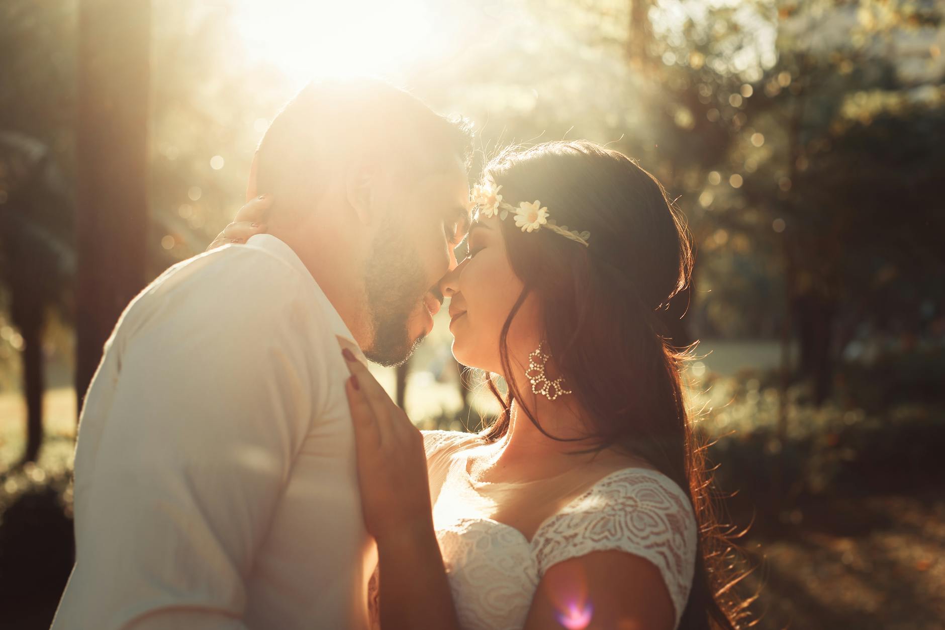 A couple shares a tender kiss during their outdoor wedding photoshoot at sunset. - rebuild marriage intimacy