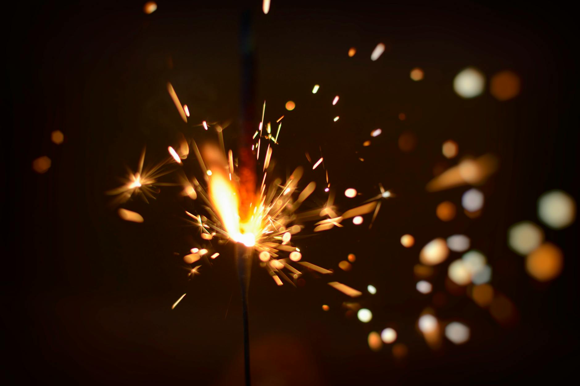 Capture the energy of fireworks with this close-up of a sparking firecracker, bursting with light. - reignite relationship spark