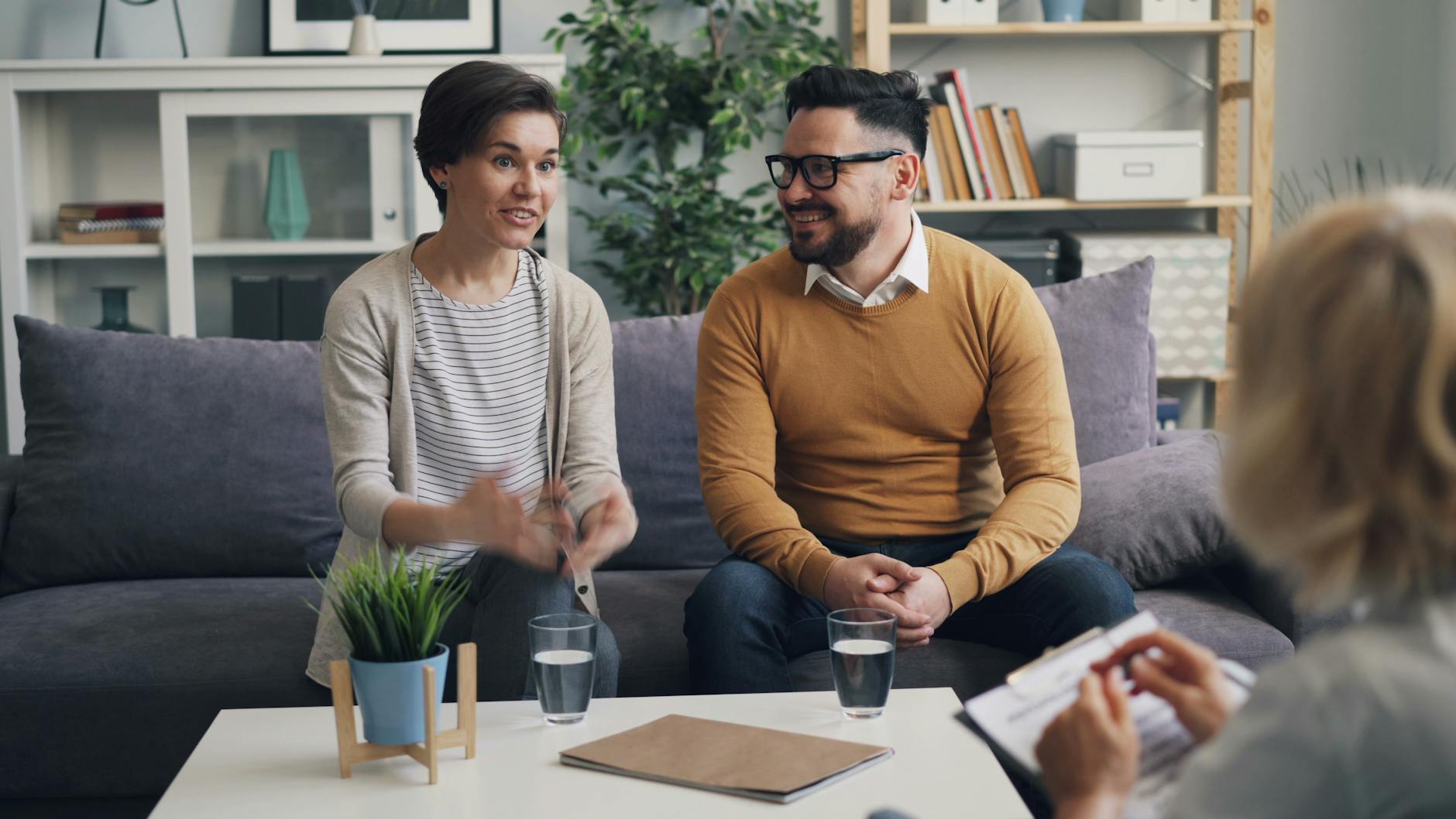 A couple discussing with a therapist during a counseling session indoors. - relationship renewal therapy