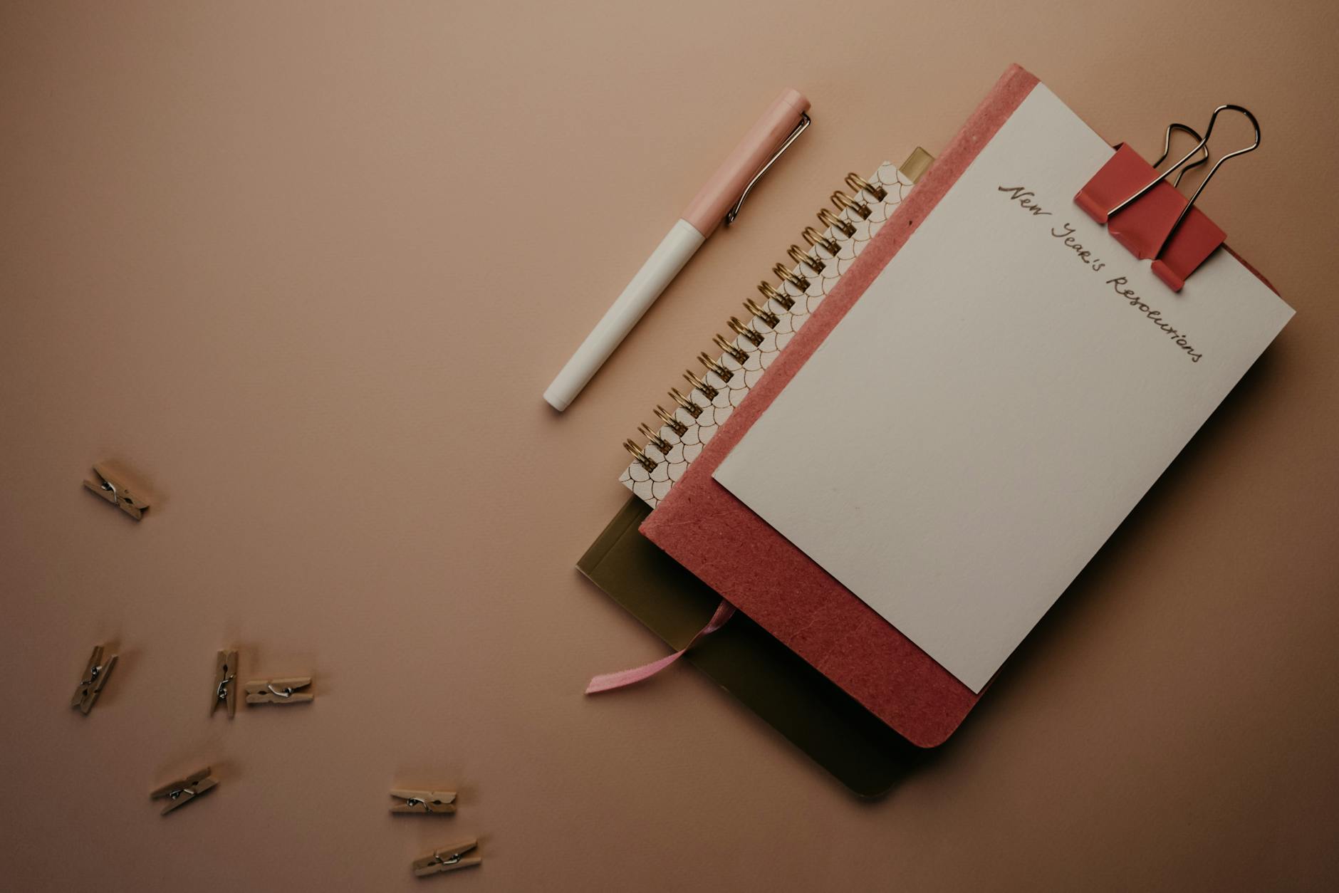 Image of a New Year's resolution notebook with a pen and clips in a flat lay arrangement. - what is a resolution
