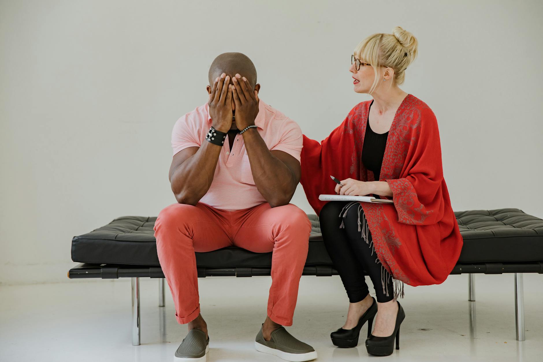 A therapist comforts a distressed man during a counseling session, focusing on mental health. - sad therapist
