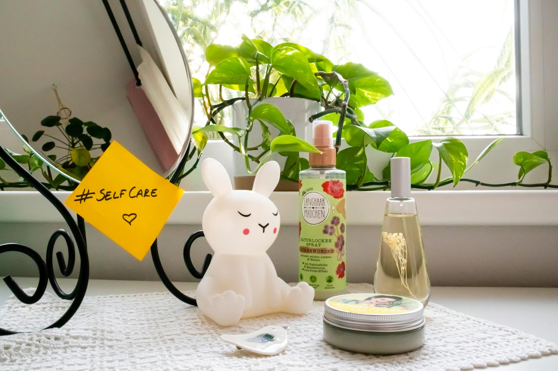 A soothing self-care corner with a bunny lamp, cosmetics, and a mirror, perfect for a relaxing routine. - self care habits