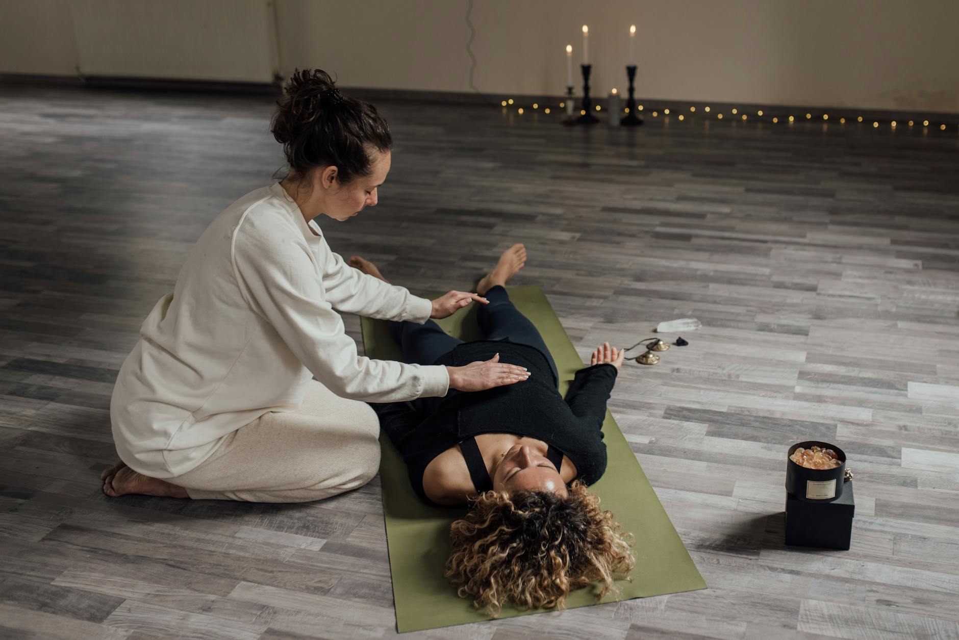A serene indoor setting capturing a therapist using Reiki techniques on a client. - somatic healing