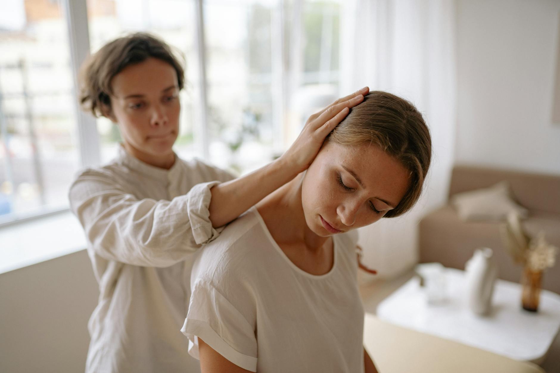 A therapist gently assists a client with a relaxation technique in a calm indoor setting. - somatic healing