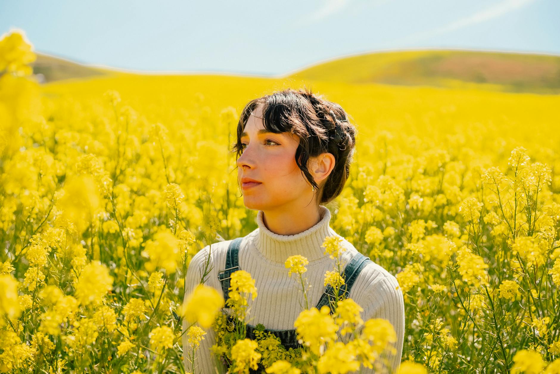 Portrait of a woman surrounded by vibrant yellow flowers in a spring field. - spring allergies anxiety