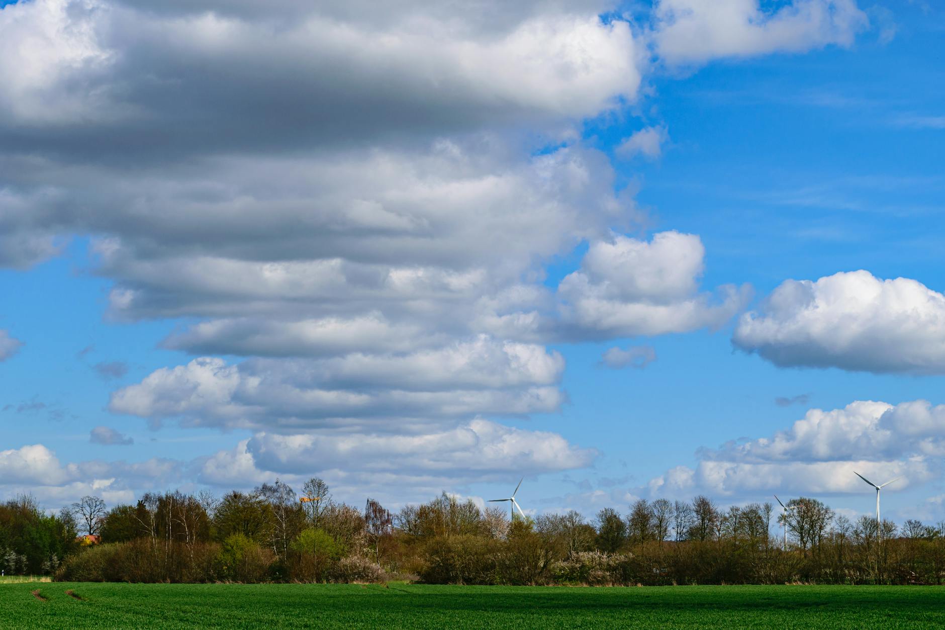 Beautiful spring day in Coesfeld, Germany, showcasing wind turbines under a dynamic cloud-filled sky. - spring energy slump