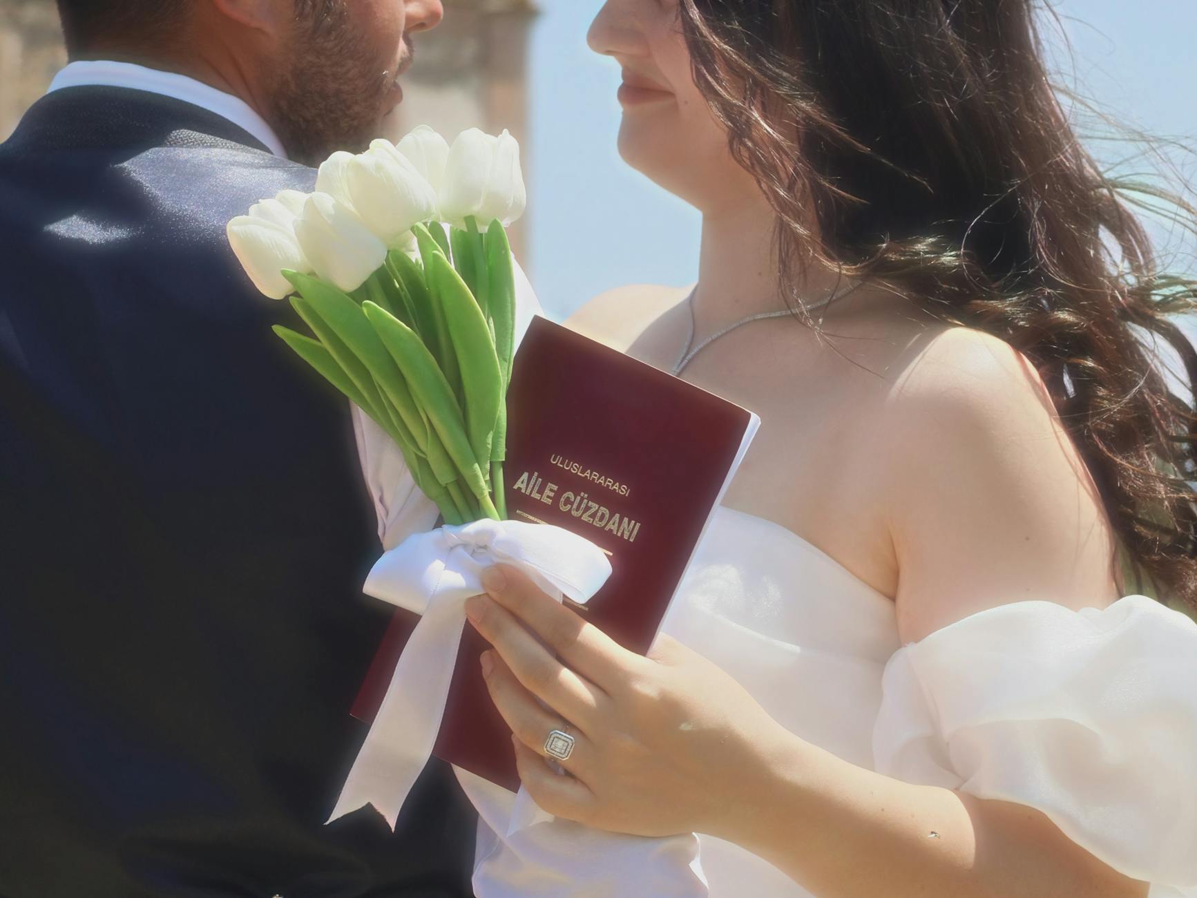 Bride with tulips and marriage certificate on wedding day celebration outdoors. - spring marriage joy