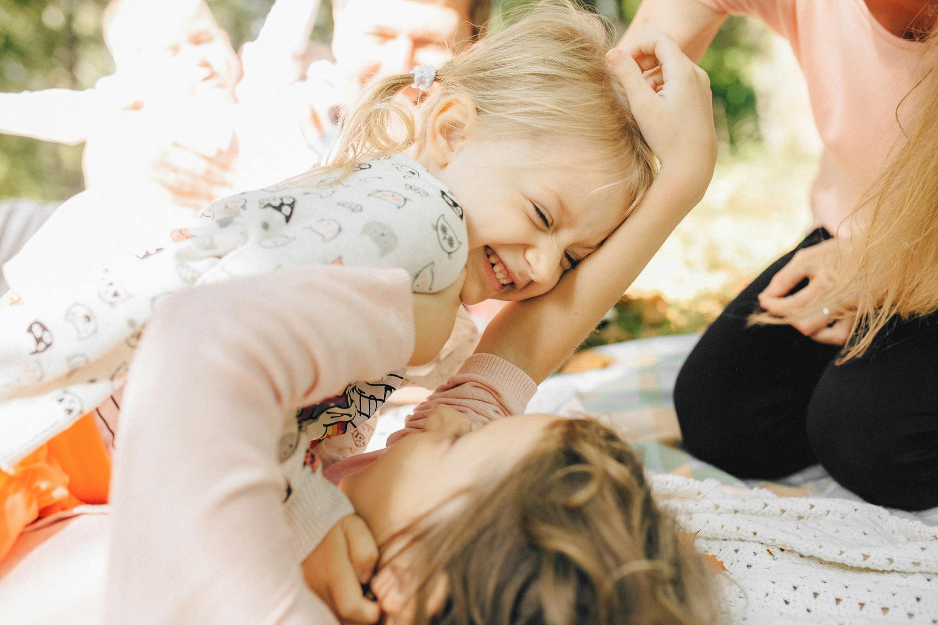 Two young siblings laughing and playing together on a sunny day, capturing the essence of childhood happiness. - step sibling rivalry