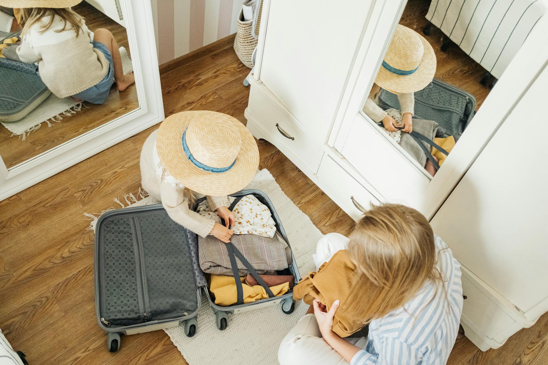 Child packing suitcase with help from mother, preparing for a summer trip. - summer vacation planning
